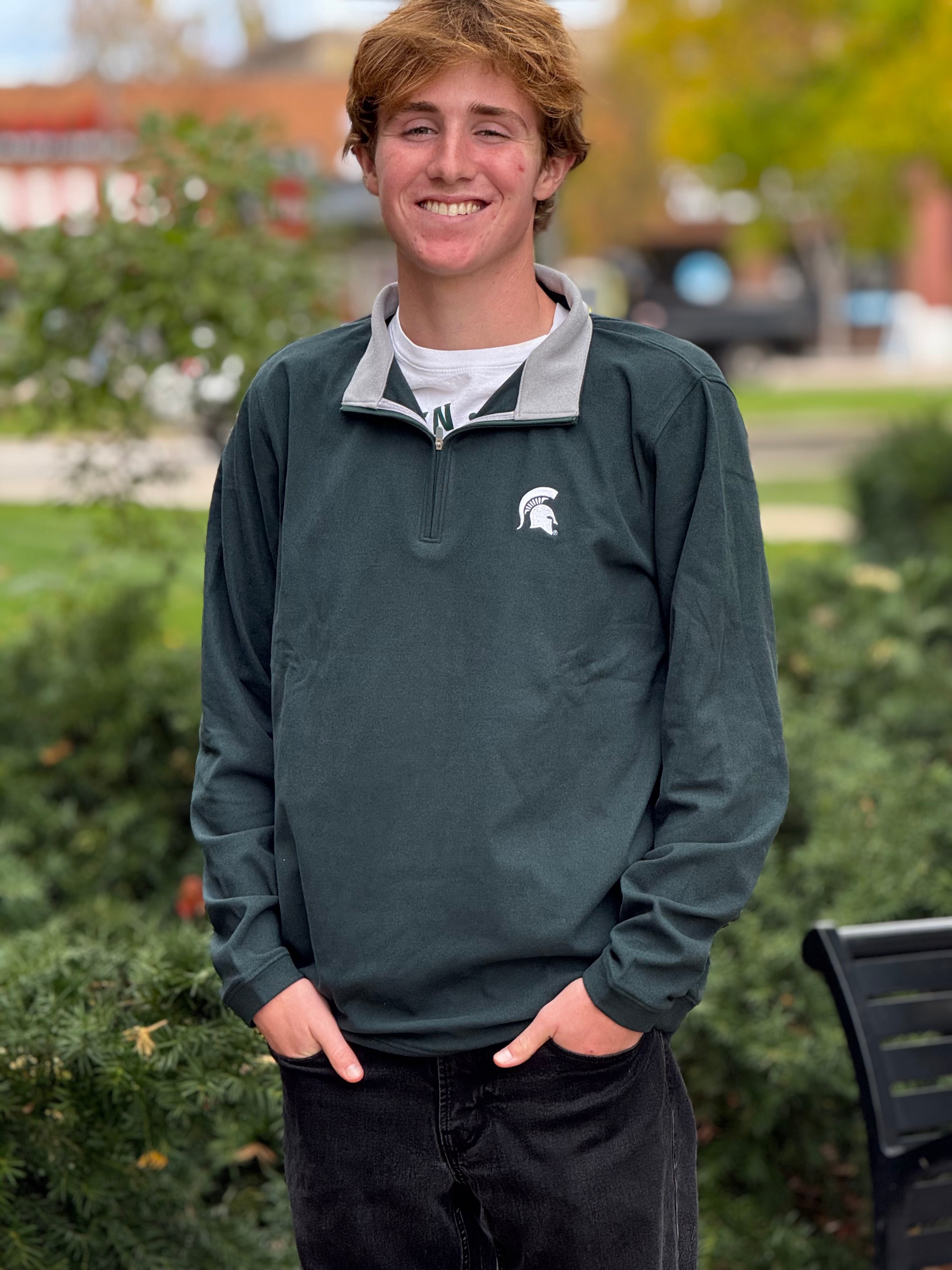 Dark green quarter zip with a contrast gray inside the collar and a embroidered white Spartan helmet logo on the left upper chest.