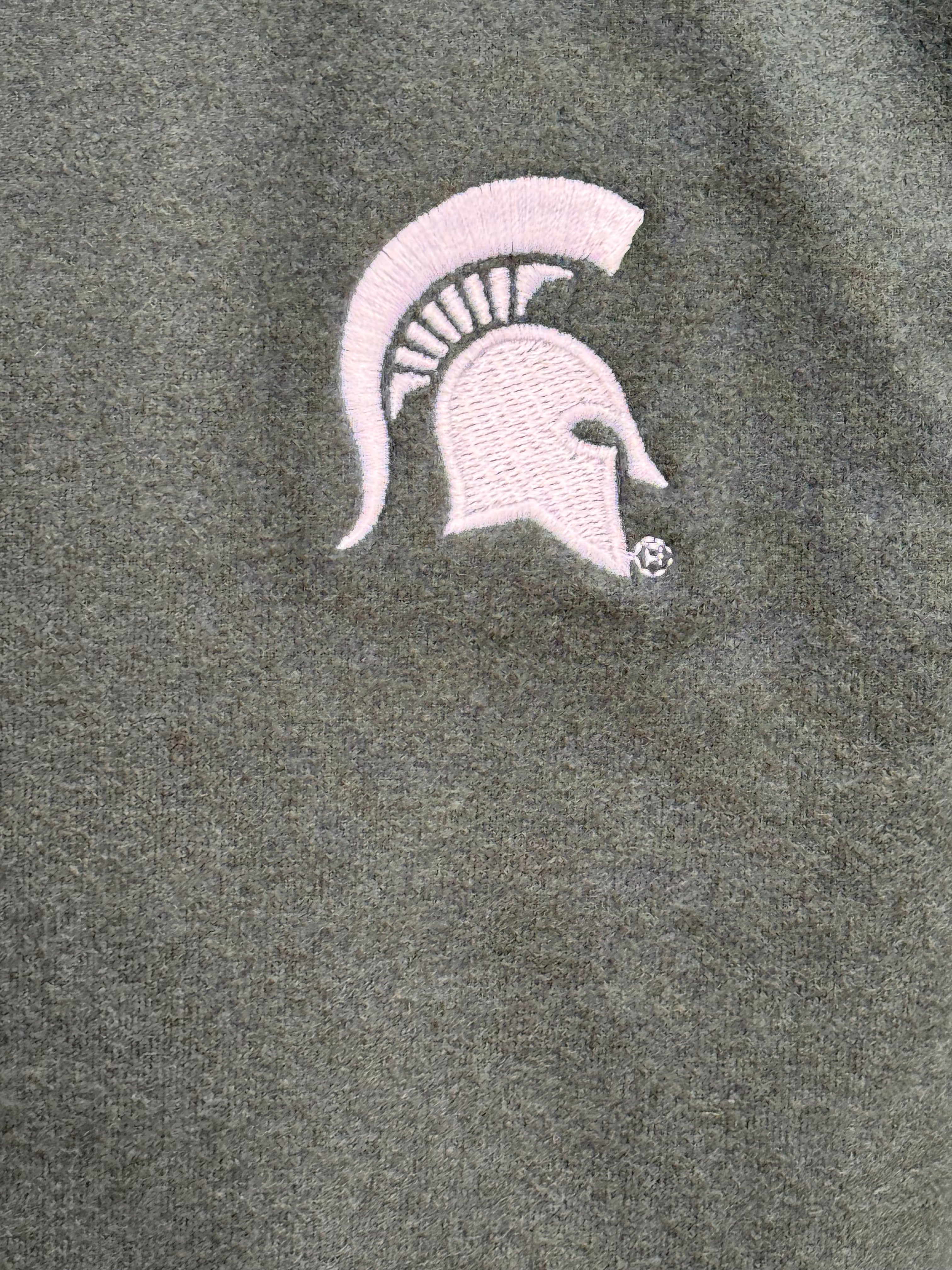 Close up of the dark gray quarter-zip, showing the embroidered Spartan helmet logo on the left upper chest.