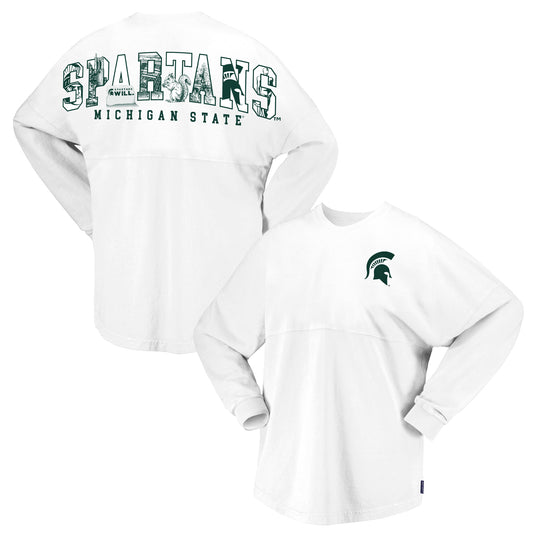 Front and back views of a white Michigan State Spartans oversized long-sleeve sweatshirt displayed on a light gray background. The front features a green Spartan helmet logo on the left chest. The back showcases large “SPARTANS” lettering filled with Michigan State-themed artwork, including Beaumont Tower, a squirrel, the Spartan helmet logo, a “Spartans Will.” graphic, and campus-inspired illustrations, with “MICHIGAN STATE” printed below in green block letters.