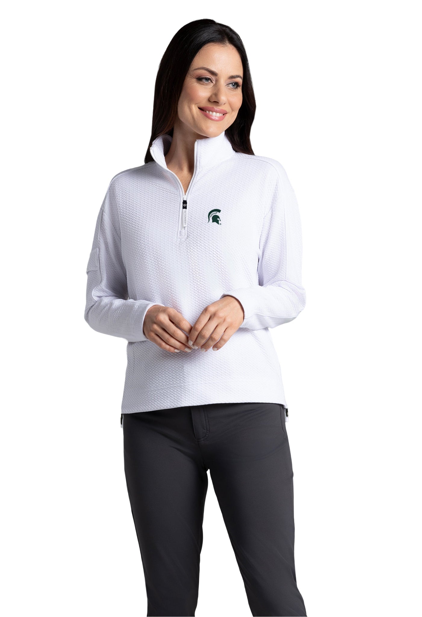 Person wearing a white quarter-zip pullover with a small green logo on the left chest and dark pants; face is blurred out.