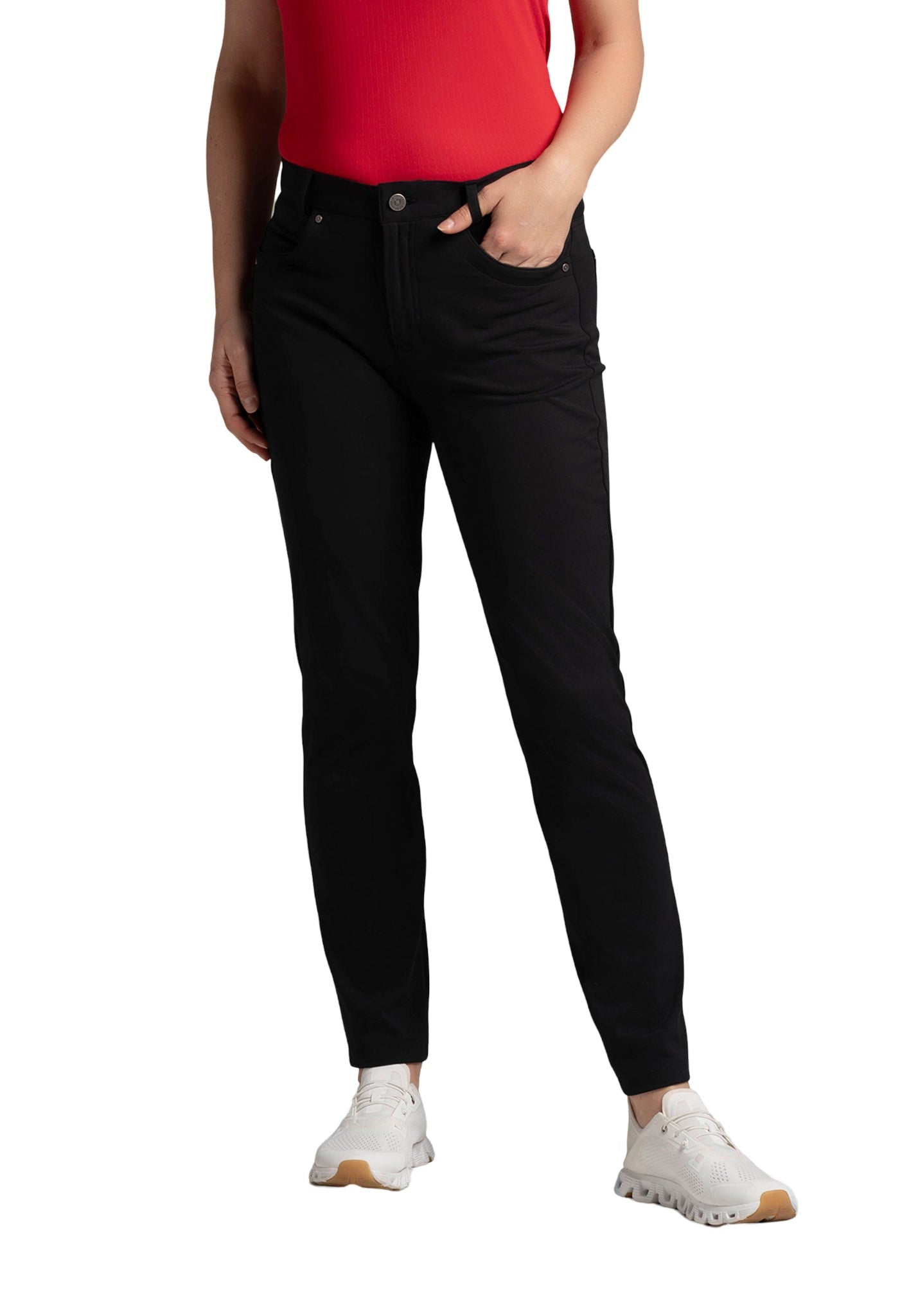 Person standing with one hand in the pocket, wearing a red top, black pants, and white sneakers.