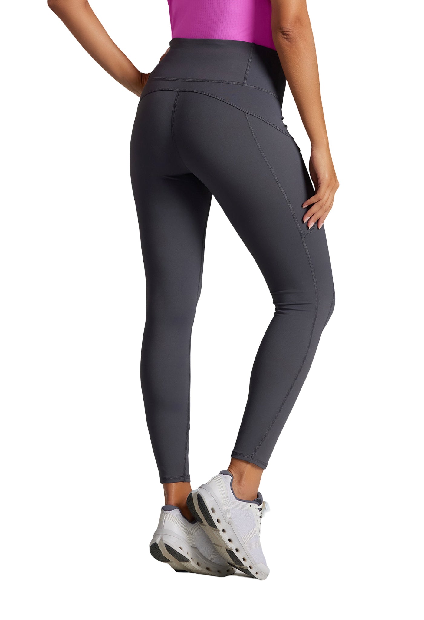 Rear view of a person wearing dark gray leggings, white sneakers, and a pink top