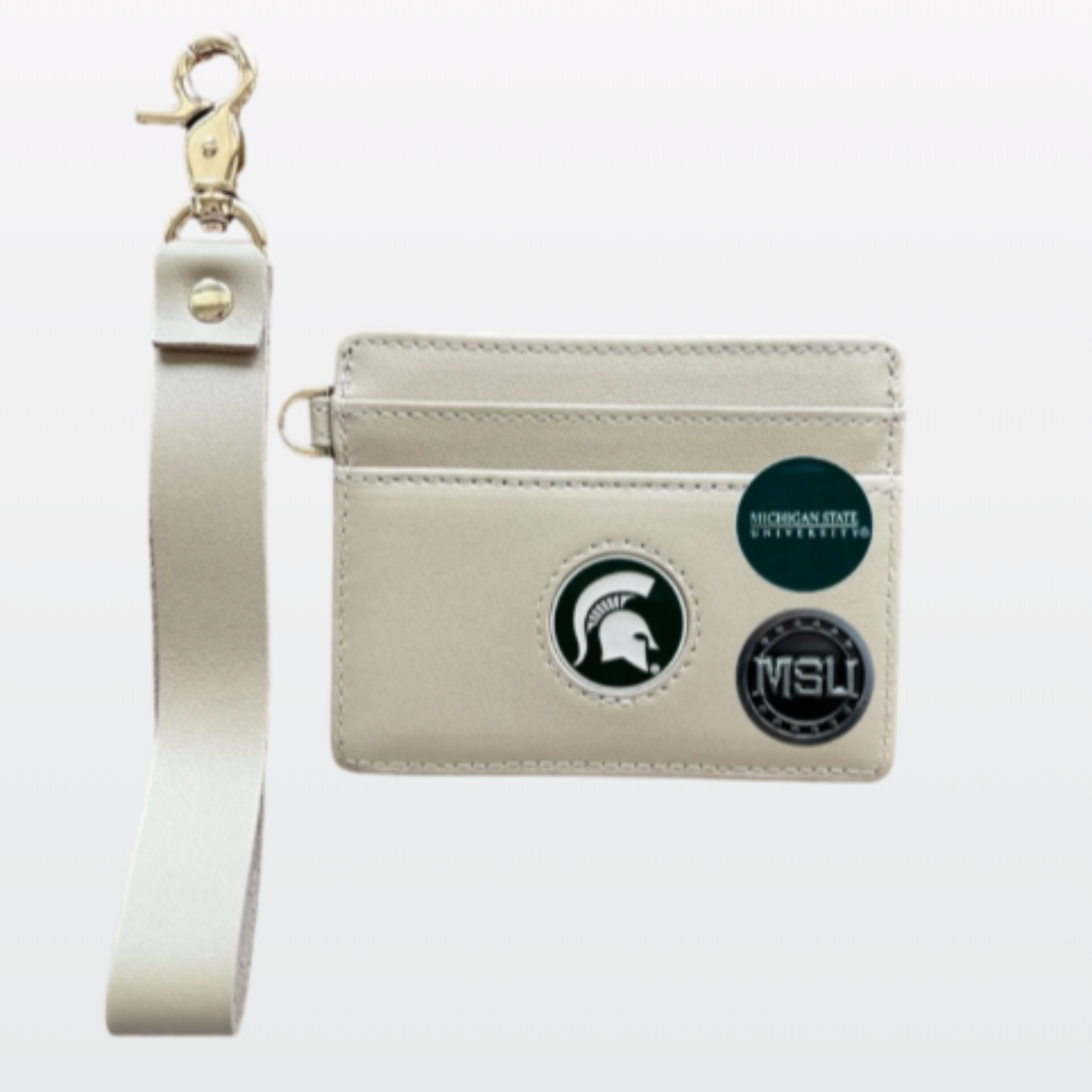 A beige leather wristlet wallet with a detachable strap and three magnetic attachments featuring Michigan State branding.