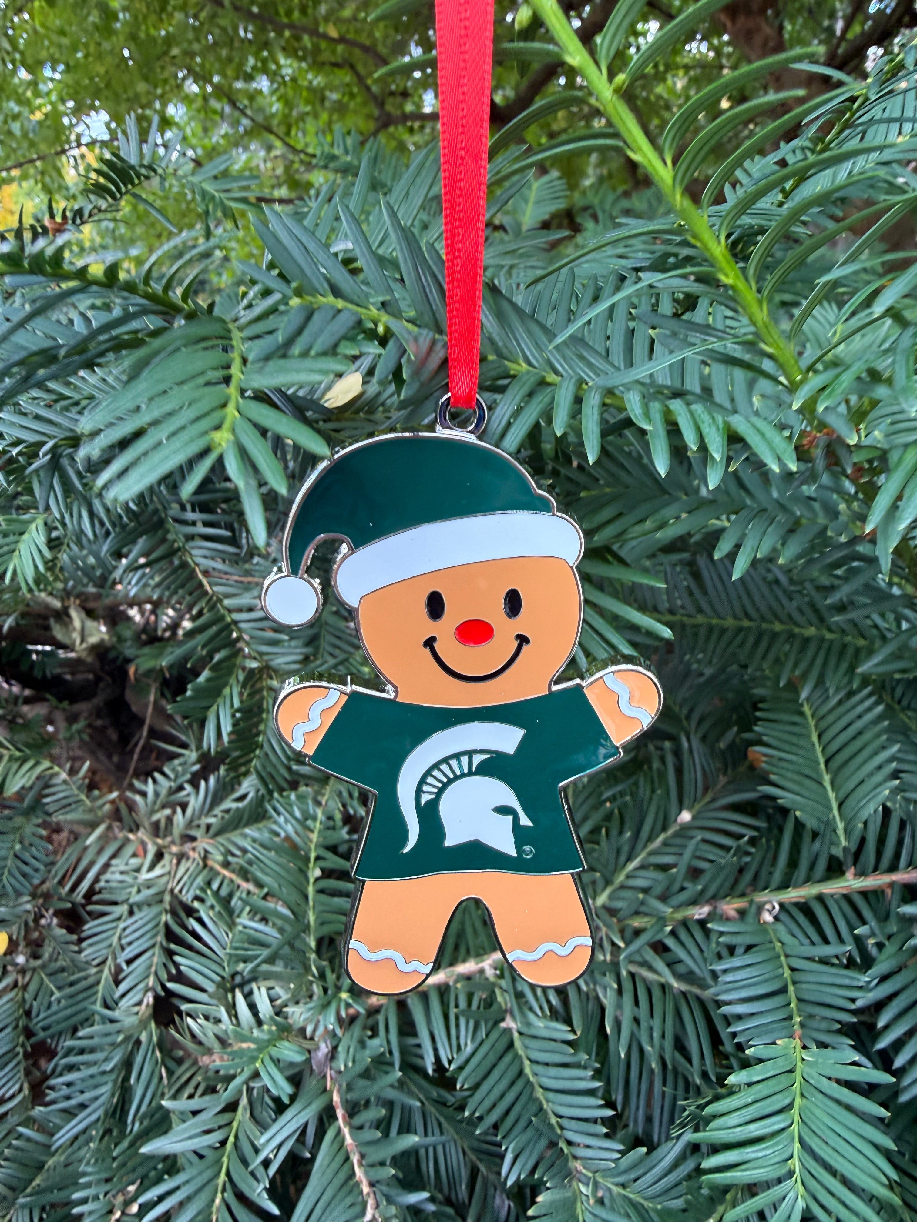 Decorative gingerbread man ornament with a green and white festive hat on and green T-shirt with a white Spartan helmet logo on the front.