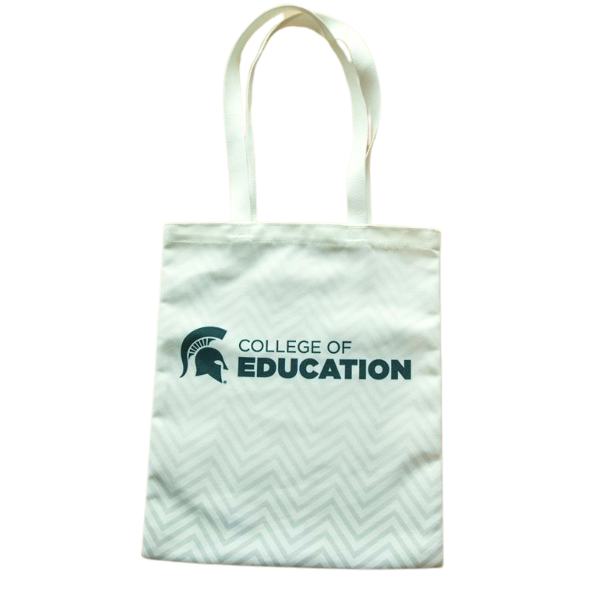 A white canvas tote with a chevron design and green College of Education logo and Spartan helmet. The chevron design fades from a darker gray at the bottom to a lighter gray at the top.