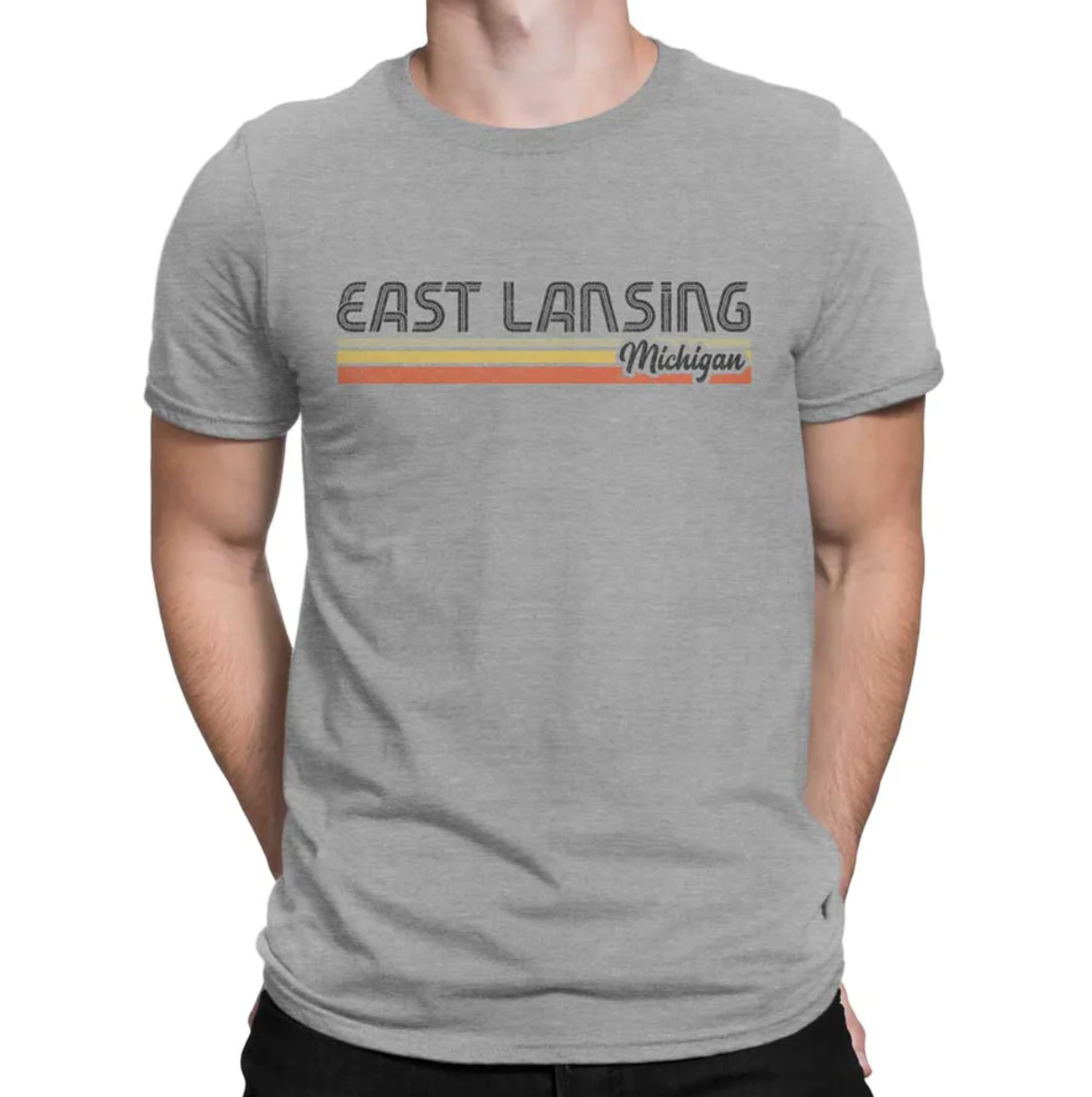 A model wearing a gray short sleeved shirt that reads "East Lansing Michigan" above yellow and orange stripes.