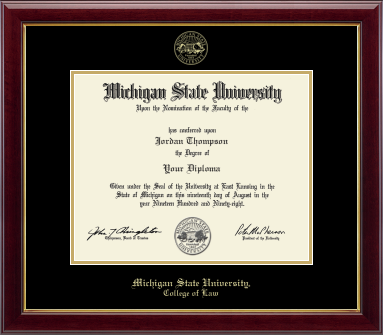 The diploma is set in a dark red wood frame with black matting with gold acescents, and includes the university seal and signatures. 'Michigan State University, College of Law' is printed at the bottom