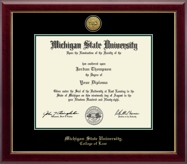 The diploma is displayed in a dark wood frame with a black matte with tartan green accents and gold trim on inner frame, and includes signatures from university officials. In gold and cursive writing is Michigan State University. Below in gold cursive letters is College of Law.
