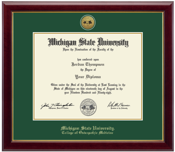 Framed Michigan State University diploma in a dark wood frame with a gold inner edge. The matte is tartan green with a gold inner border surrounding the diploma. Michigan State Seal is at the top of matte and is gold engraved. 'Michigan State University' is inscribed in gold at the bottom of the frame. Below Michigan State University is 'College of Osteopathic Medicine'.