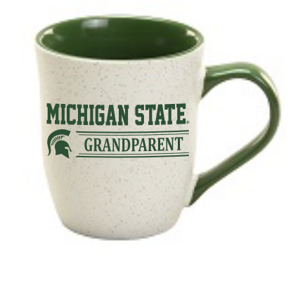 A granite mug with a speckled white body and green handle and interior. It has screen print graphics with the text 'MICHIGAN STATE GRANDPARENT' and the Spartans helmet.