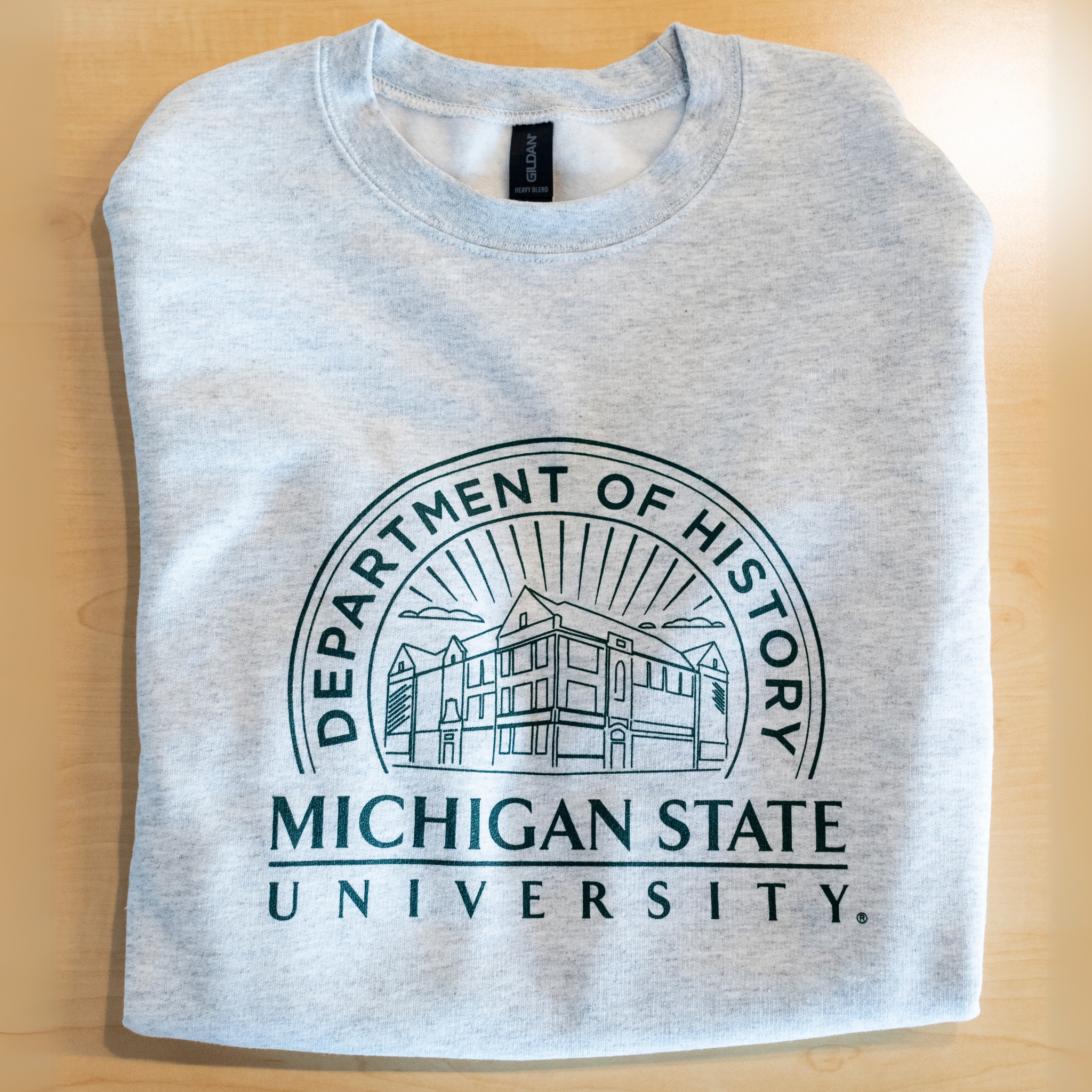Grey crewneck sweatshirt that showcases the Old Horticulture building surrounded by the text ‘Department of History’ and ‘Michigan State University’.