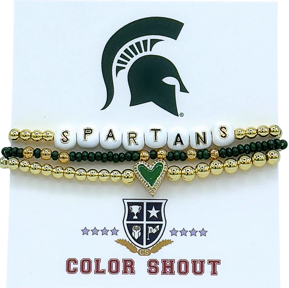 Three bracelets stacked together. The top bracelet is gold with white beads that spell out "Spartans." The middle bracelet is green with gold enamel. The last bracelet is gold with a green heart charm in the middle.