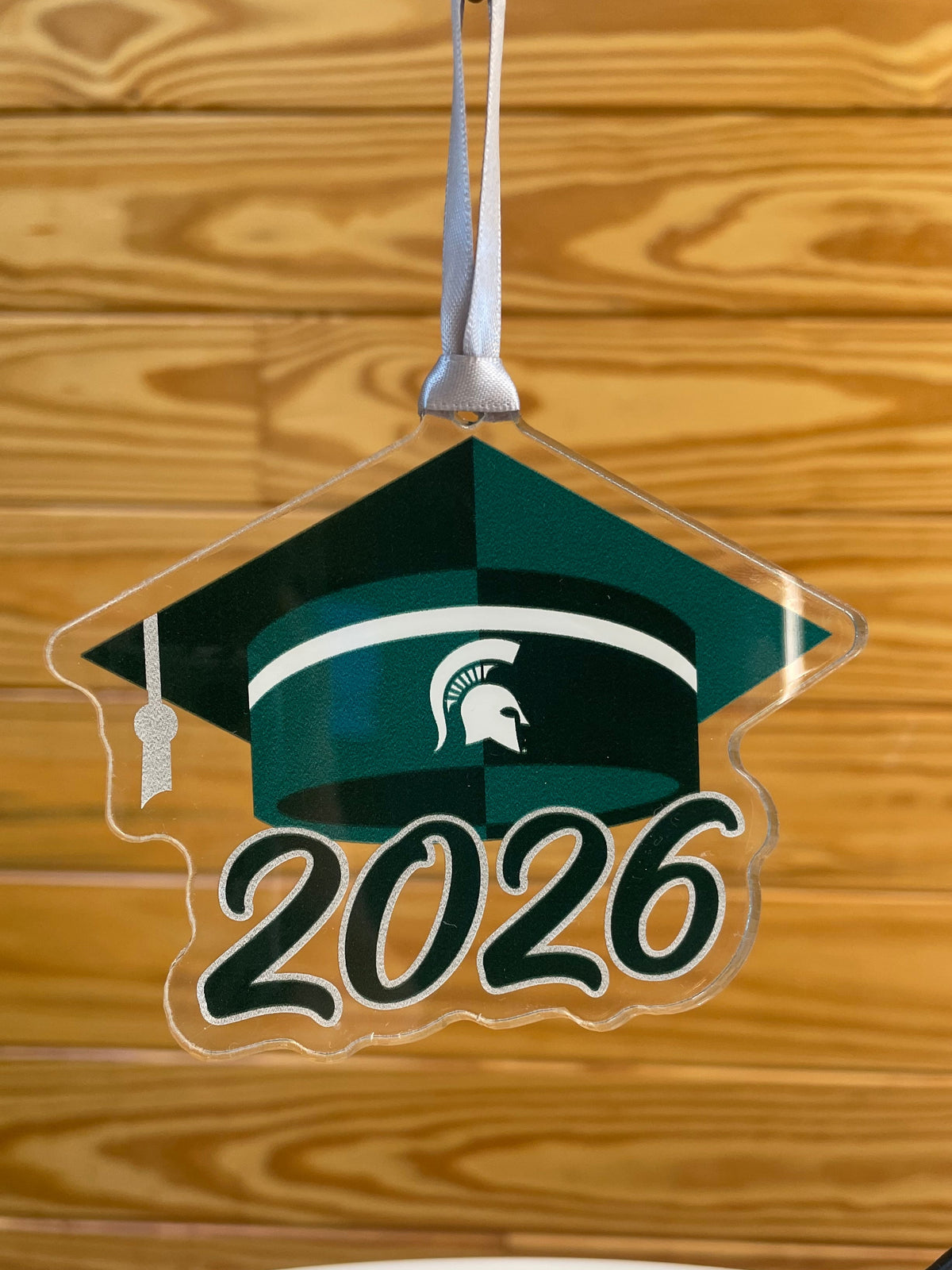 Acrylic cutout of a green graduation cap with white Spartan Helmet logo and "2026" below.