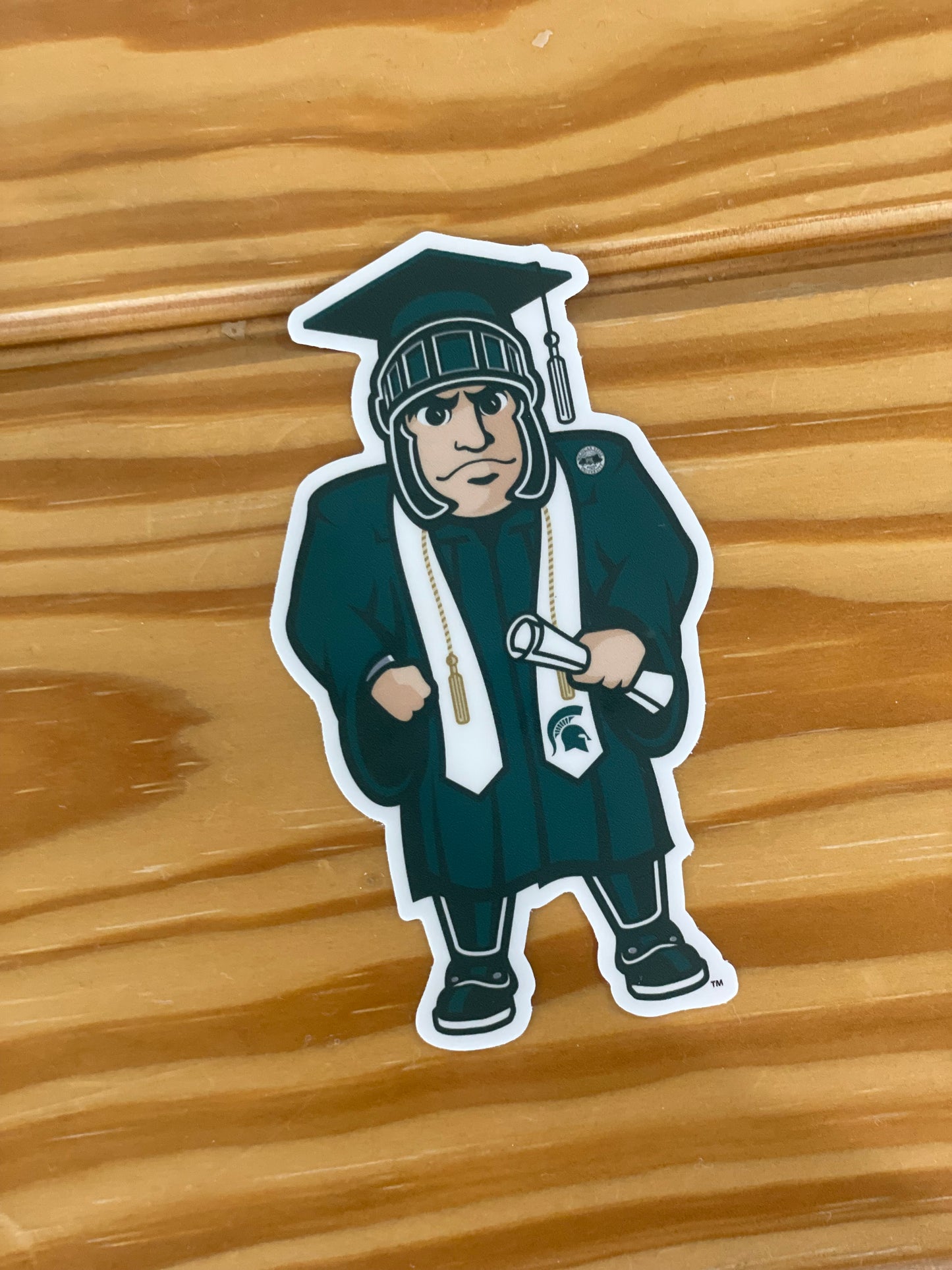 Sticker of Graduation Sparty in MSU cap and gown.