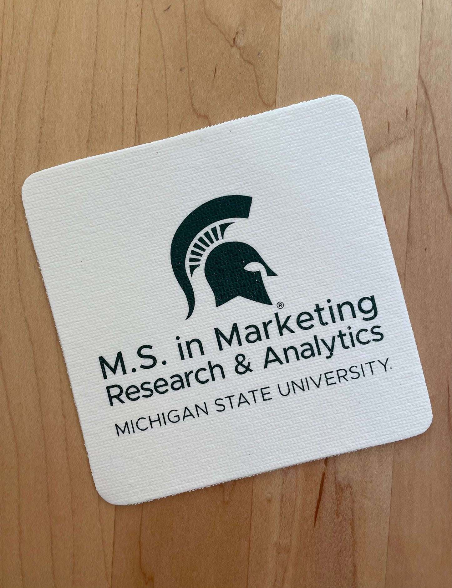 White jar opener with the M.S. in Marketing Research & Analytics Michigan State University logo printed in green.