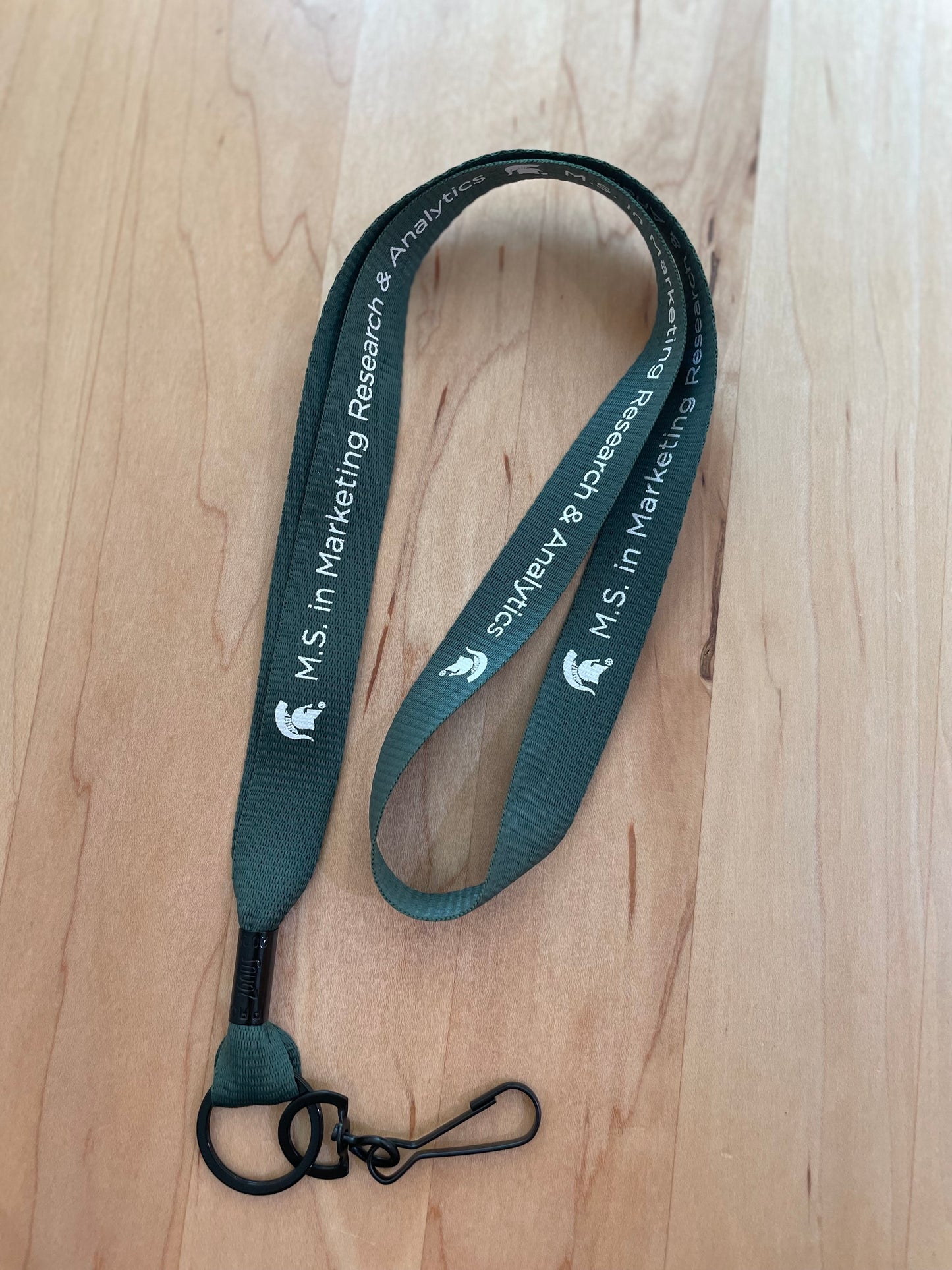 Green lanyard with the M.S. in Marketing Research & Analytics Michigan State University logo printed in white.