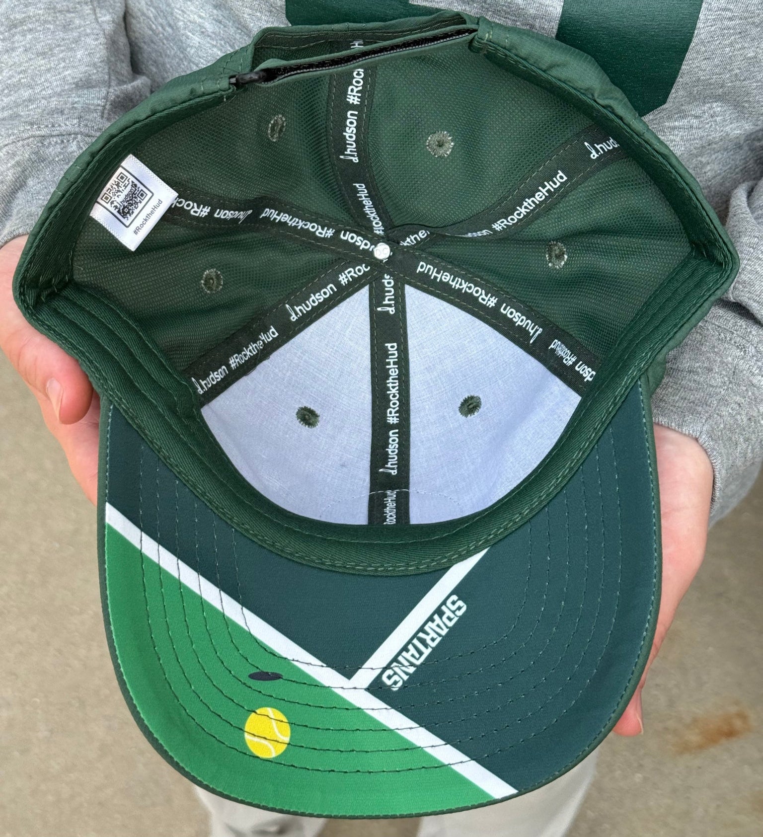 Underside of hat showing a Spartans tennis court design.