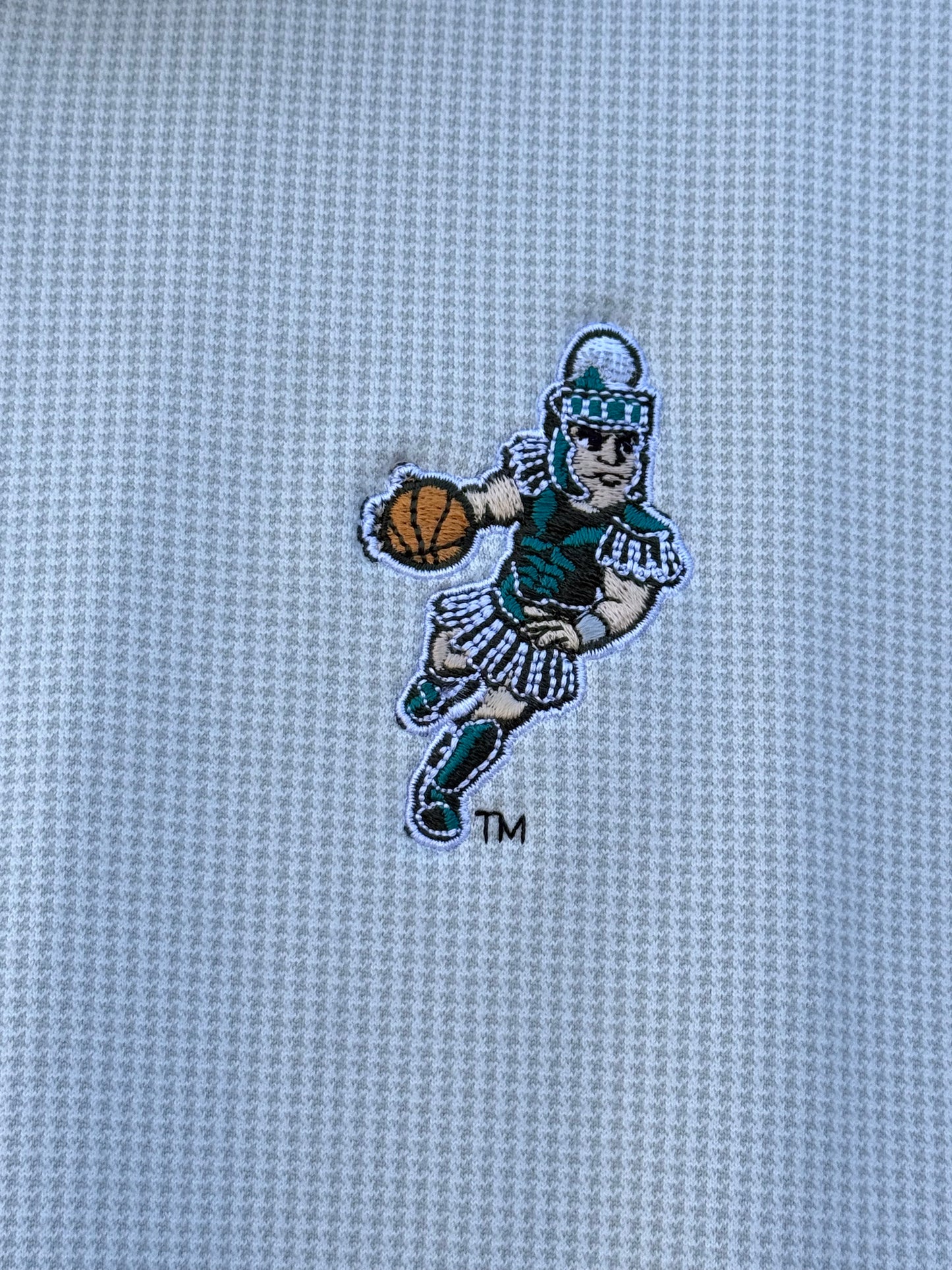 Close up of the embroidered basketball Sparty logo on the upper left chest.