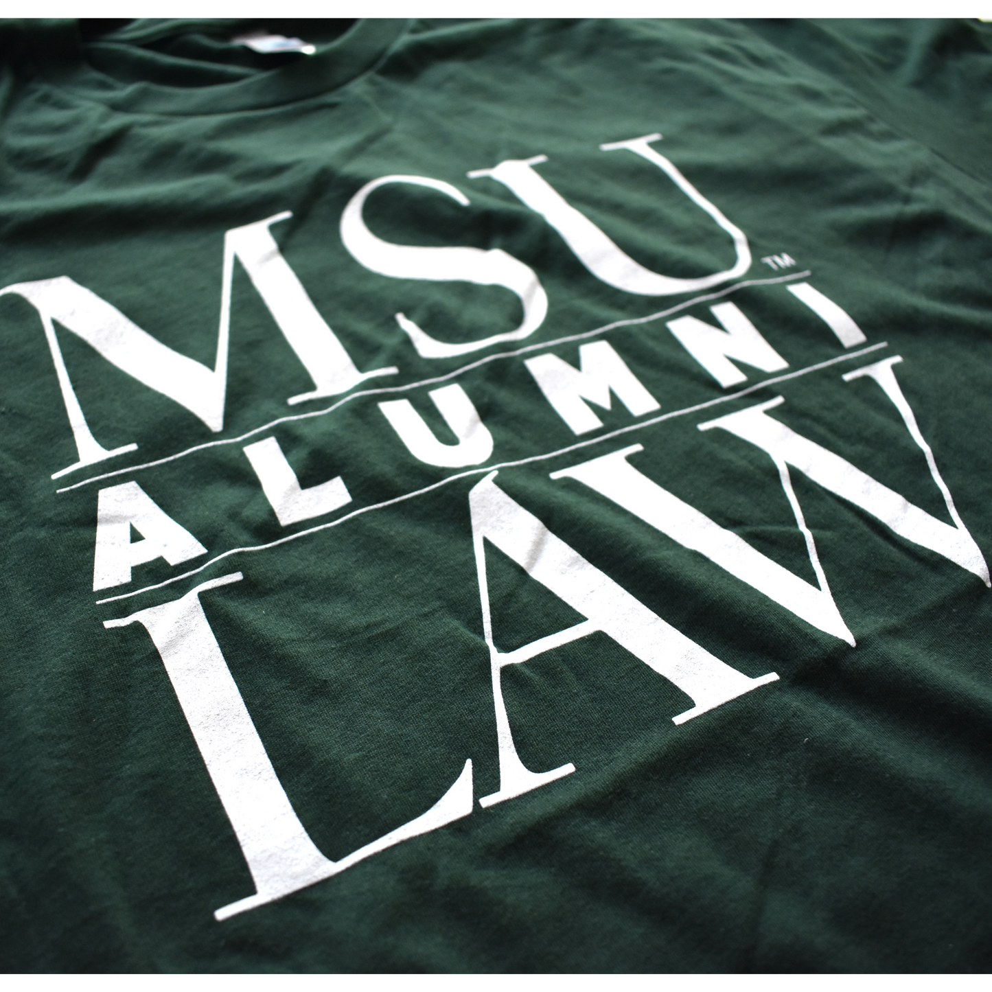 Close-up of graphic text covering three lines that read "MSU Law Alumni" in all caps, with alumni being in the center separated by two thin white lines.
