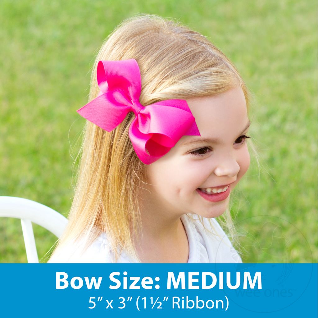 A toddler with a medium-sized pink bow in their hair.