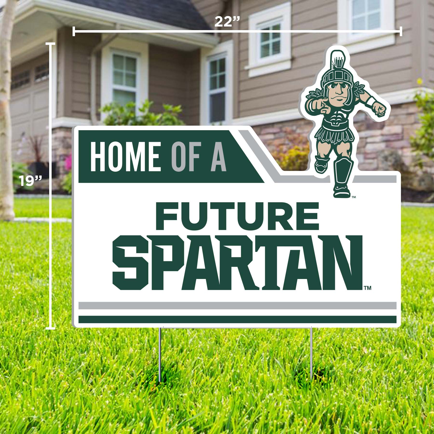 A lawn sign with the text 'HOME OF A FUTURE SPARTAN' featuring an illustration of a Running Sparty. The sign is placed on a lawn in front of a house.