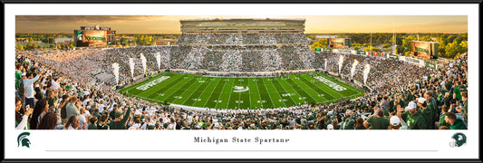 Panorama of the Michigan State Football team going head-to-head with the Western Michigan Broncos. The panorama is framed with a black standard frame and has a white border. This product measures to 40.25 inches by 13.75 inches.