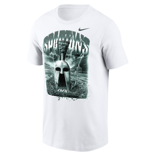White Nike Michigan State Spartans T-shirt featuring a large green-toned graphic of a Spartan helmet centered on the chest. The design includes bold “SPARTANS” lettering, lightning effects, a stadium backdrop, and “2026” at the bottom of the artwork. A Nike Swoosh logo appears above the graphic on the upper right chest. Product shown on a light gray background.