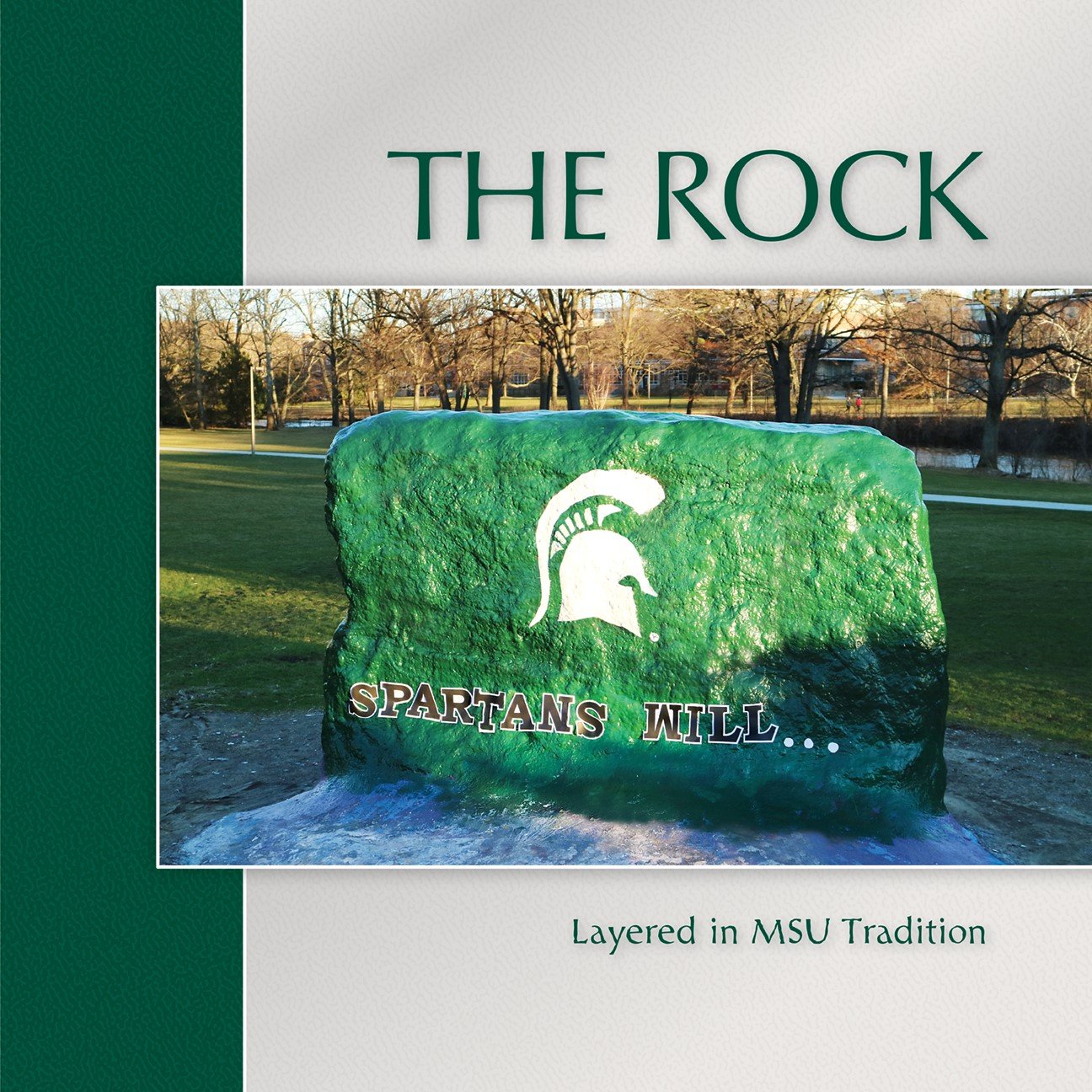 Cover of the "The Rock: Layered in MSU Tradition" Coffee Table Book featuring a picture of the rock painted with the text "Spartans Will."