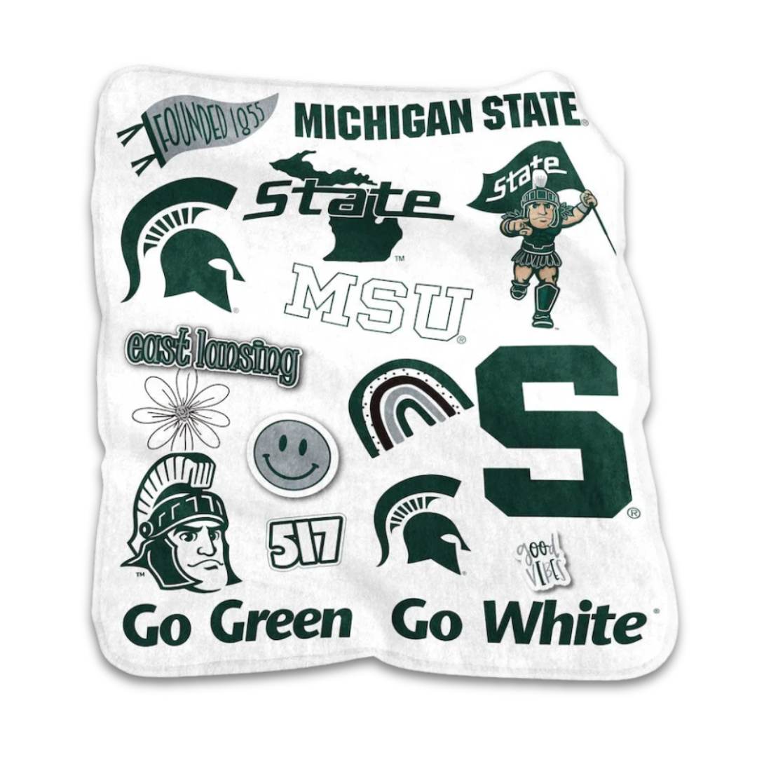 A white plush blanket with various Michigan State logos and icons patterned on it.