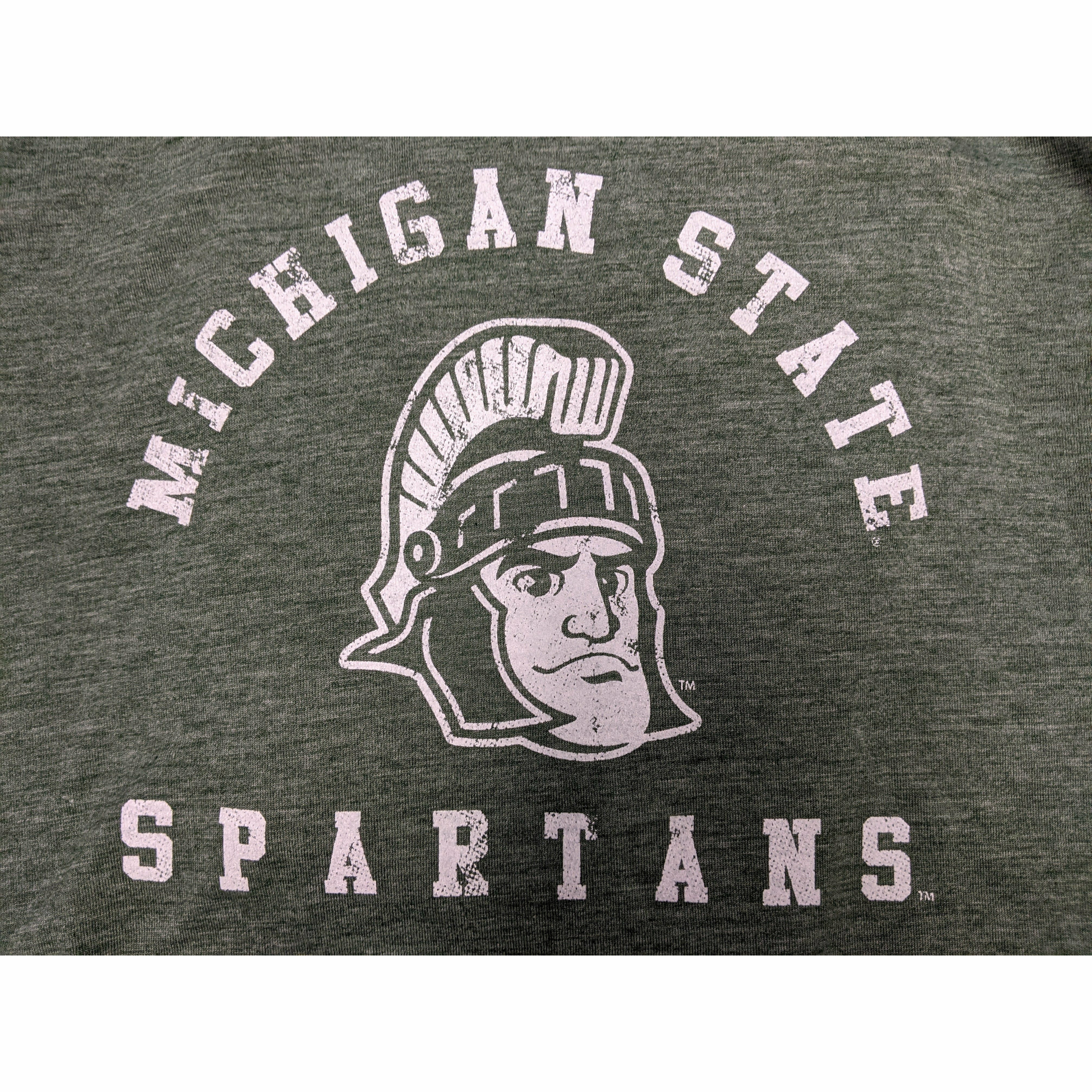 Close-up of a white screen printed rendition of Sparty's head is printed between arched text reading Michigan State and a straight line of text reading Spartans.