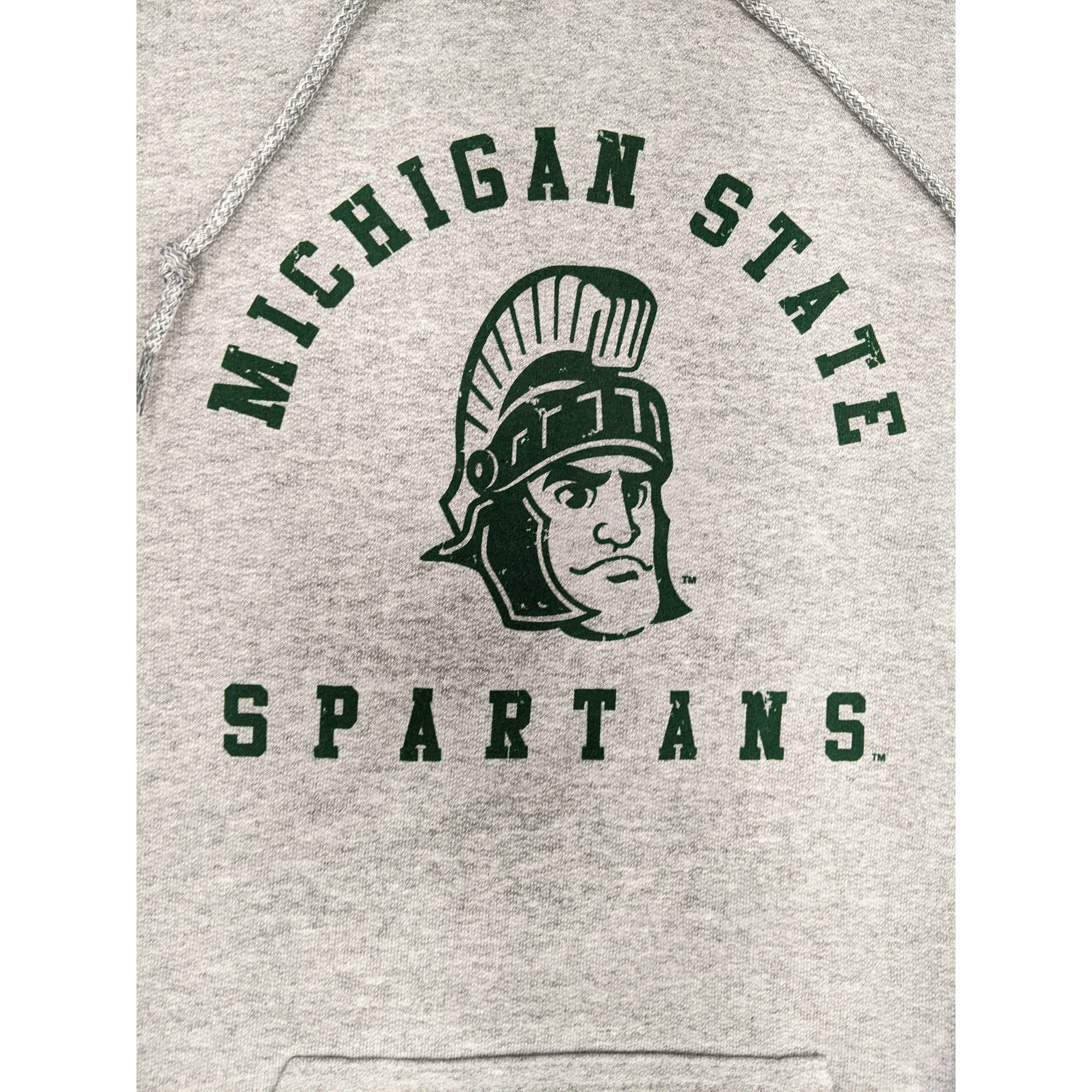 Close-up of a green screen printed rendition of Sparty's head is printed between arched text reading Michigan State and a straight line of text reading Spartans.