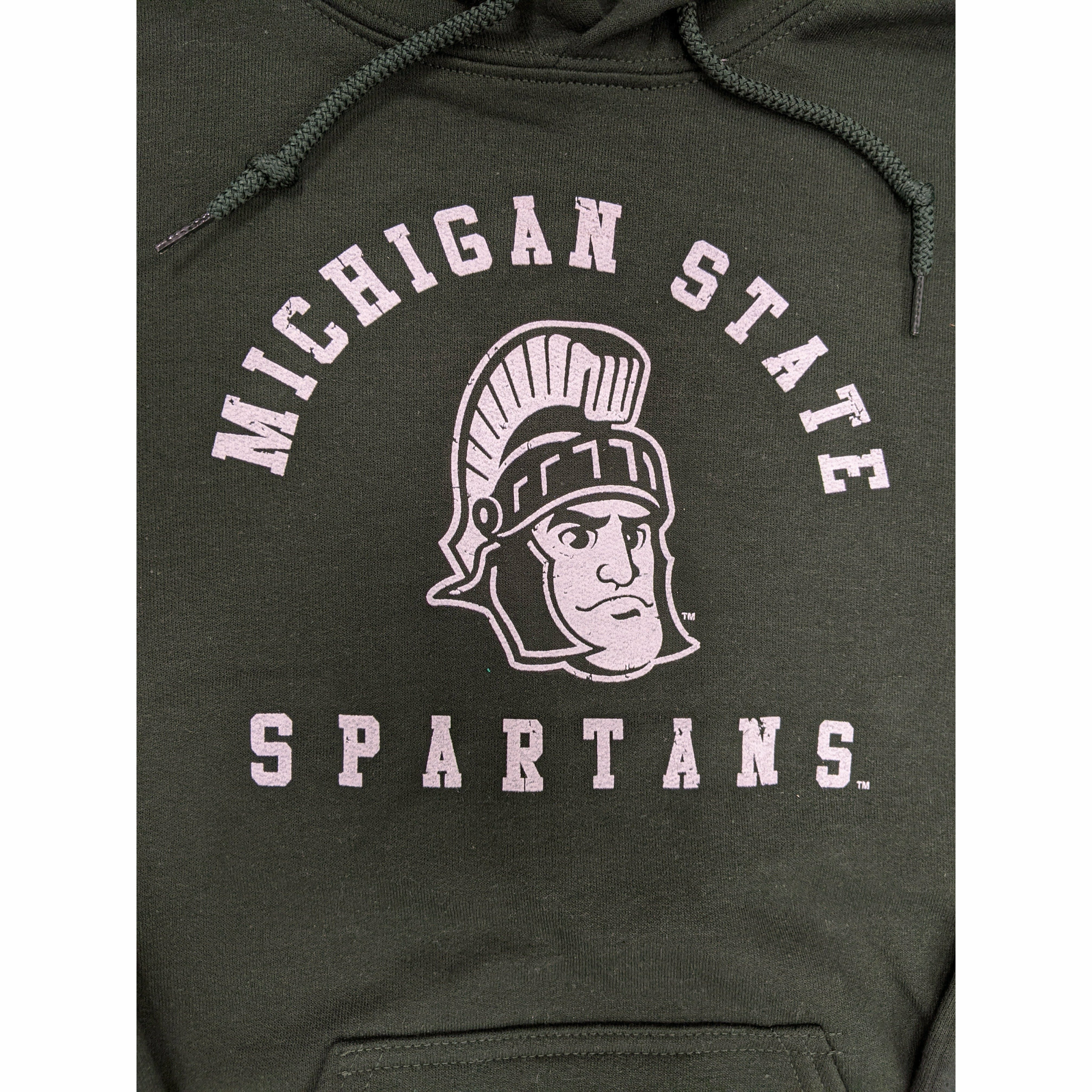 Close-up of a white screen printed rendition of Sparty's head is printed between arched text reading Michigan State and a straight line of text reading Spartans.