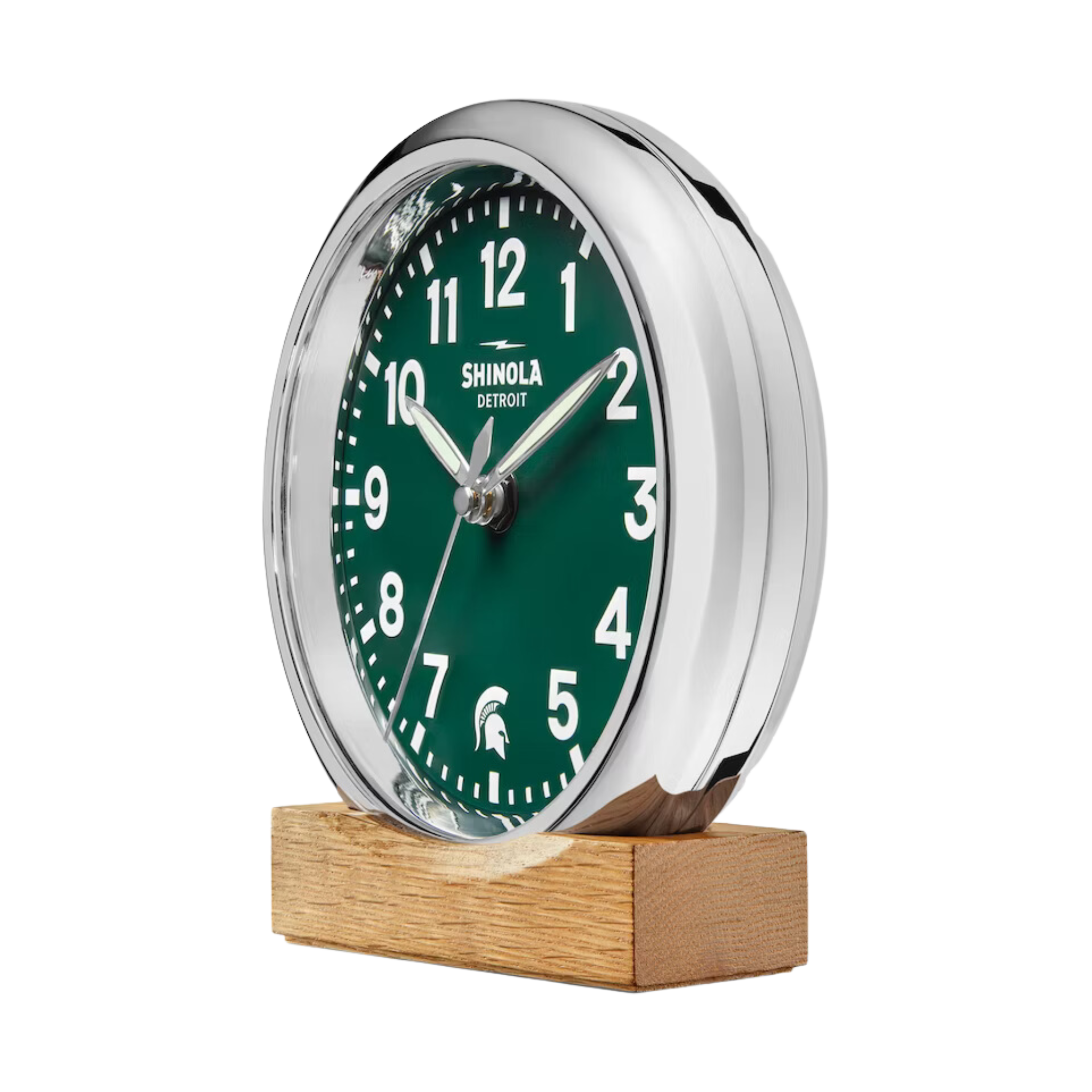 Right side of Shinola desk clock with a green face, wooden base, and silver rim. The numbers are white and there is a white Spartan helmet logo in place of the number 6.