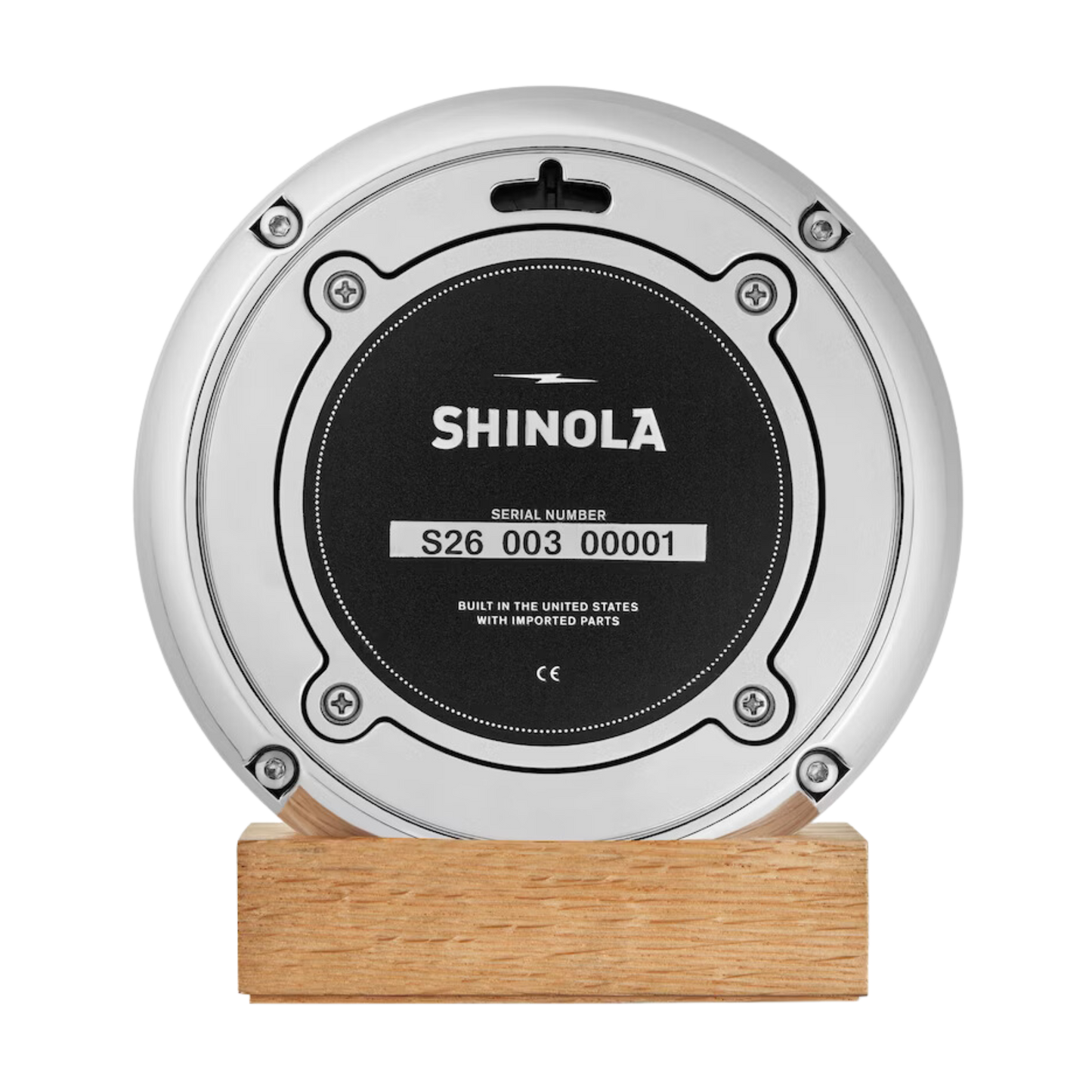Shinola desk clock case back on a wooden stand.