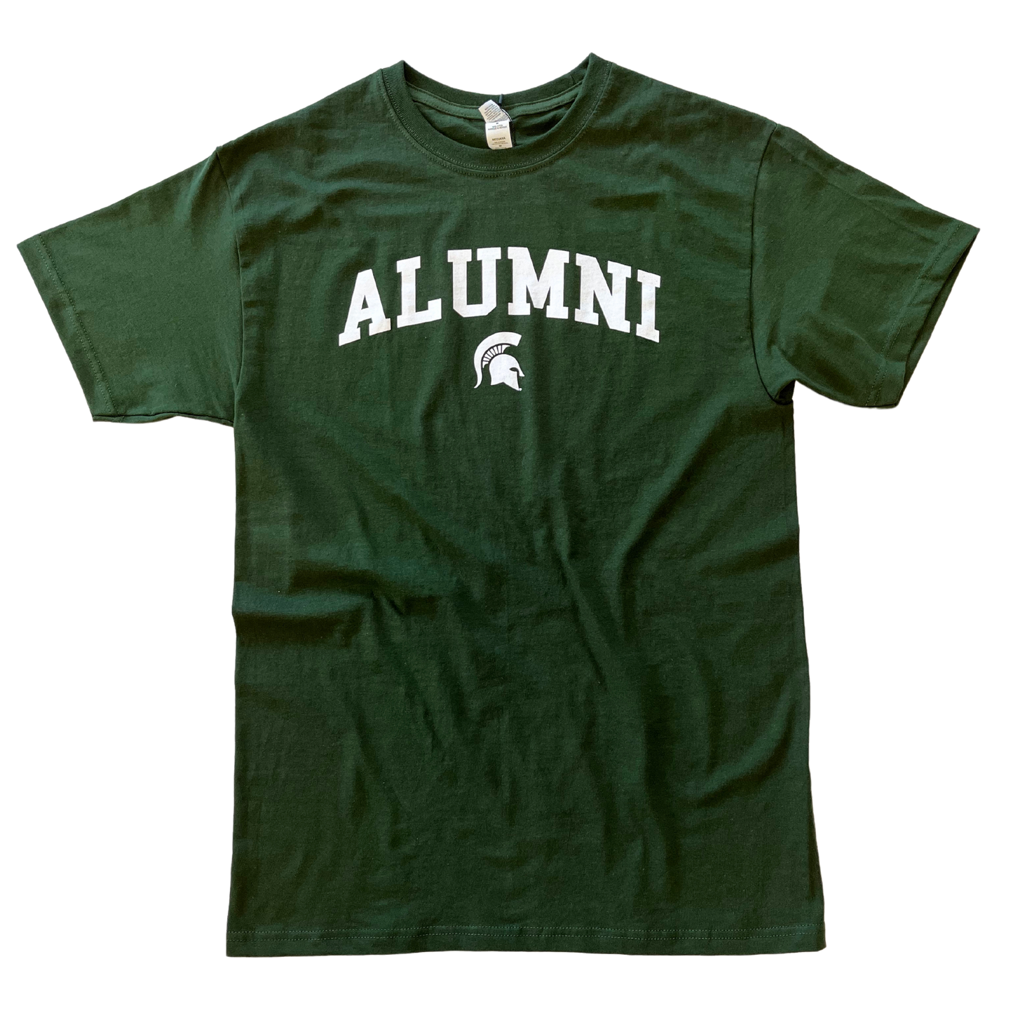 Forest green crewneck T-shirt with short sleeves. Centered on the chest, white block letters read “Alumni” in a slight arch over a small white Spartan Helmet logo.