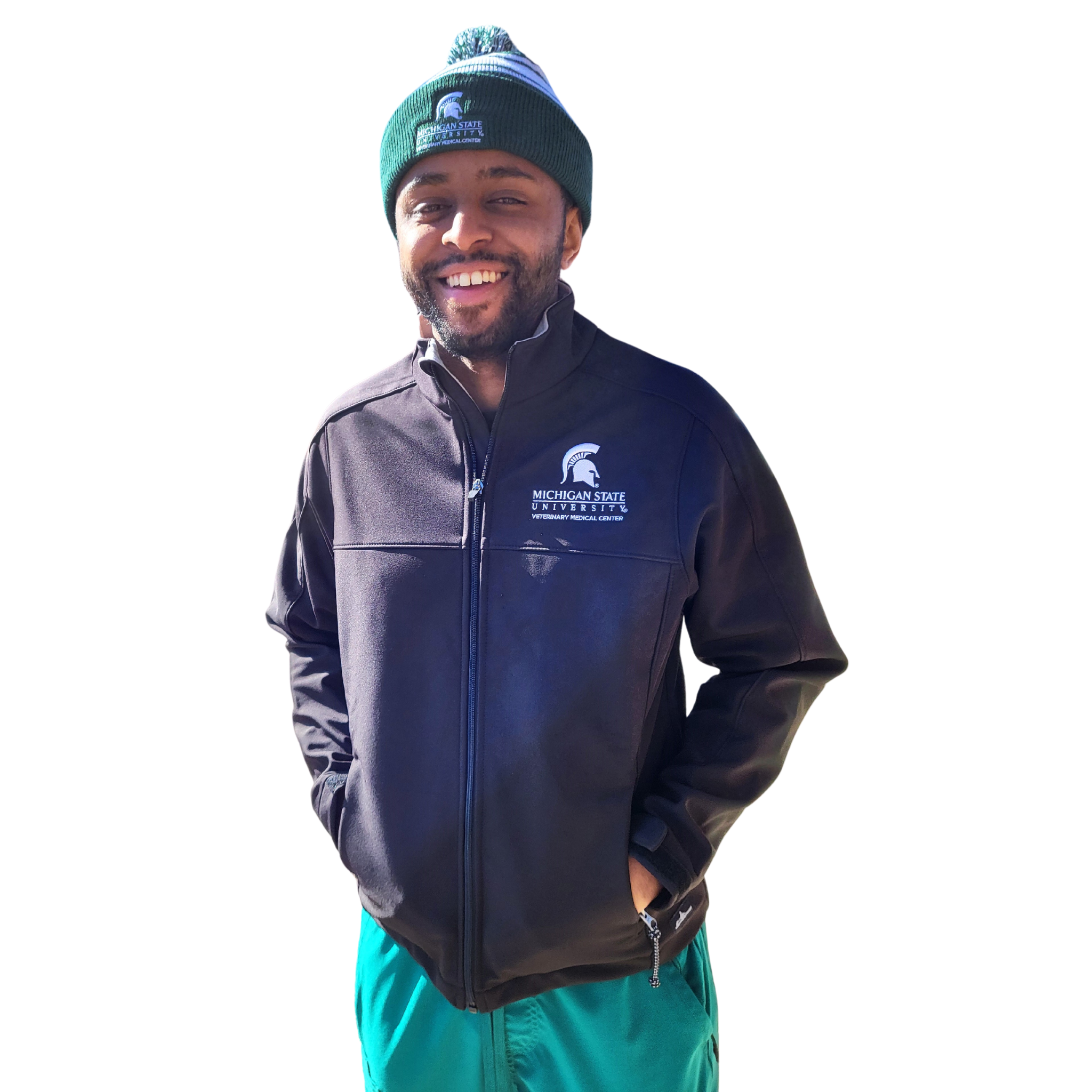 A man in green scrubs and a green beanie wearing a black full-zip jacket. The upper left chest is embroidered with a Veterinary Medical Center logo in white.