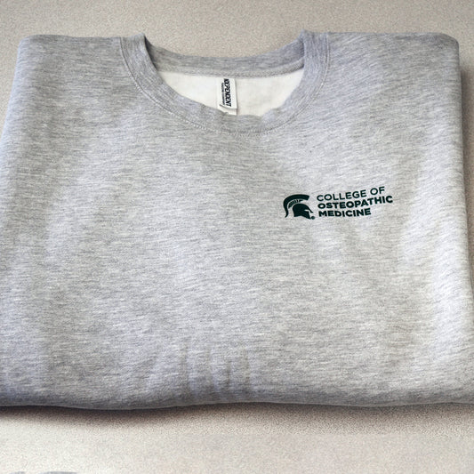 Front of heather gray crewneck sweatshirt with College of Osteopathic Medicine logo printed in forest green on the left upper chest.