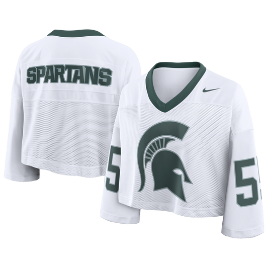 White Michigan State cropped football-style jersey with green trim at the V-neck collar, mesh front panel, oversized green Spartan helmet graphic on the chest, and the number “55 printed on both sleeves. The back features bold “SPARTANS” lettering across the shoulders, with a Nike Swoosh logo on the upper front.