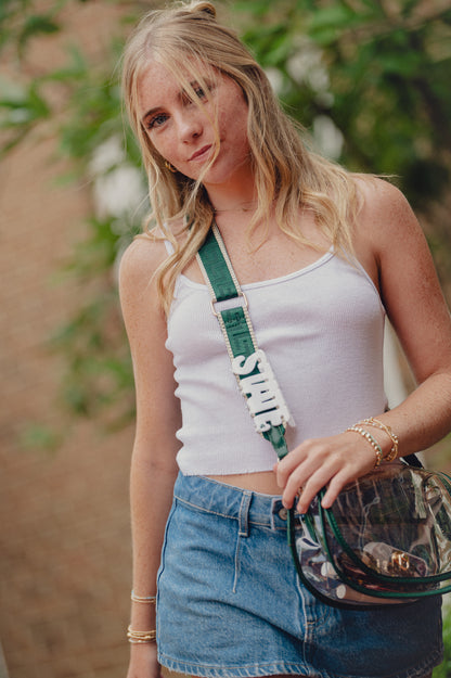 Woman wearing cross-body handbag with a white STATE hair claw clip on the strap.
