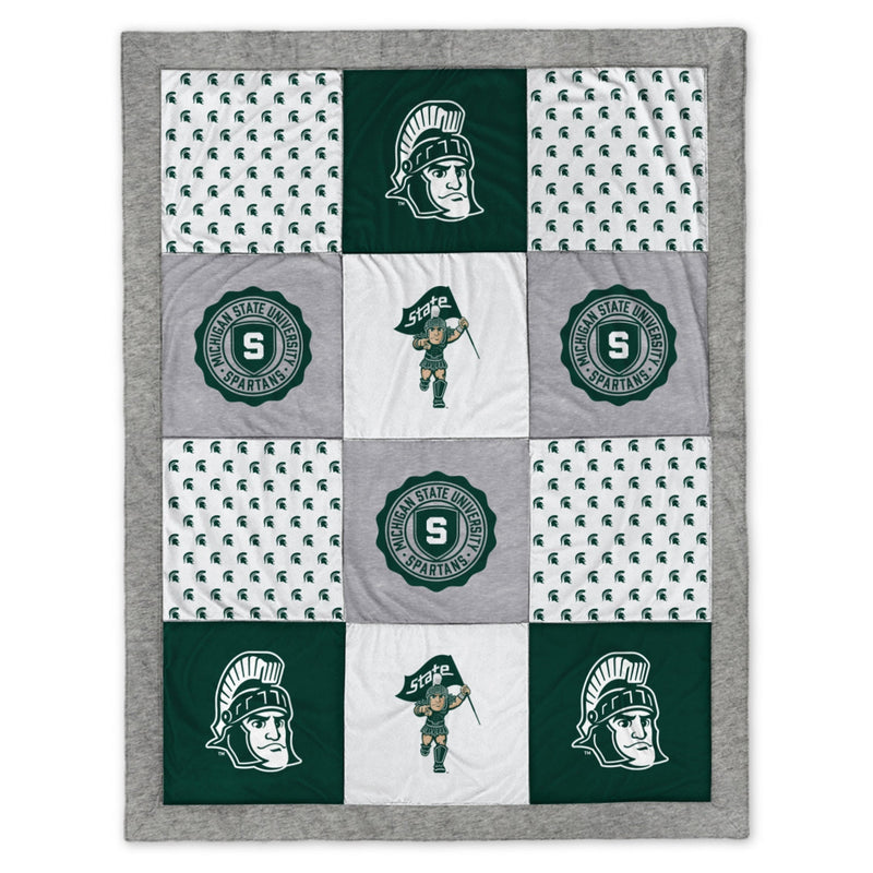 A patchwork blanket of gray, green, and white fabric with various MSU and Sparty motifs.