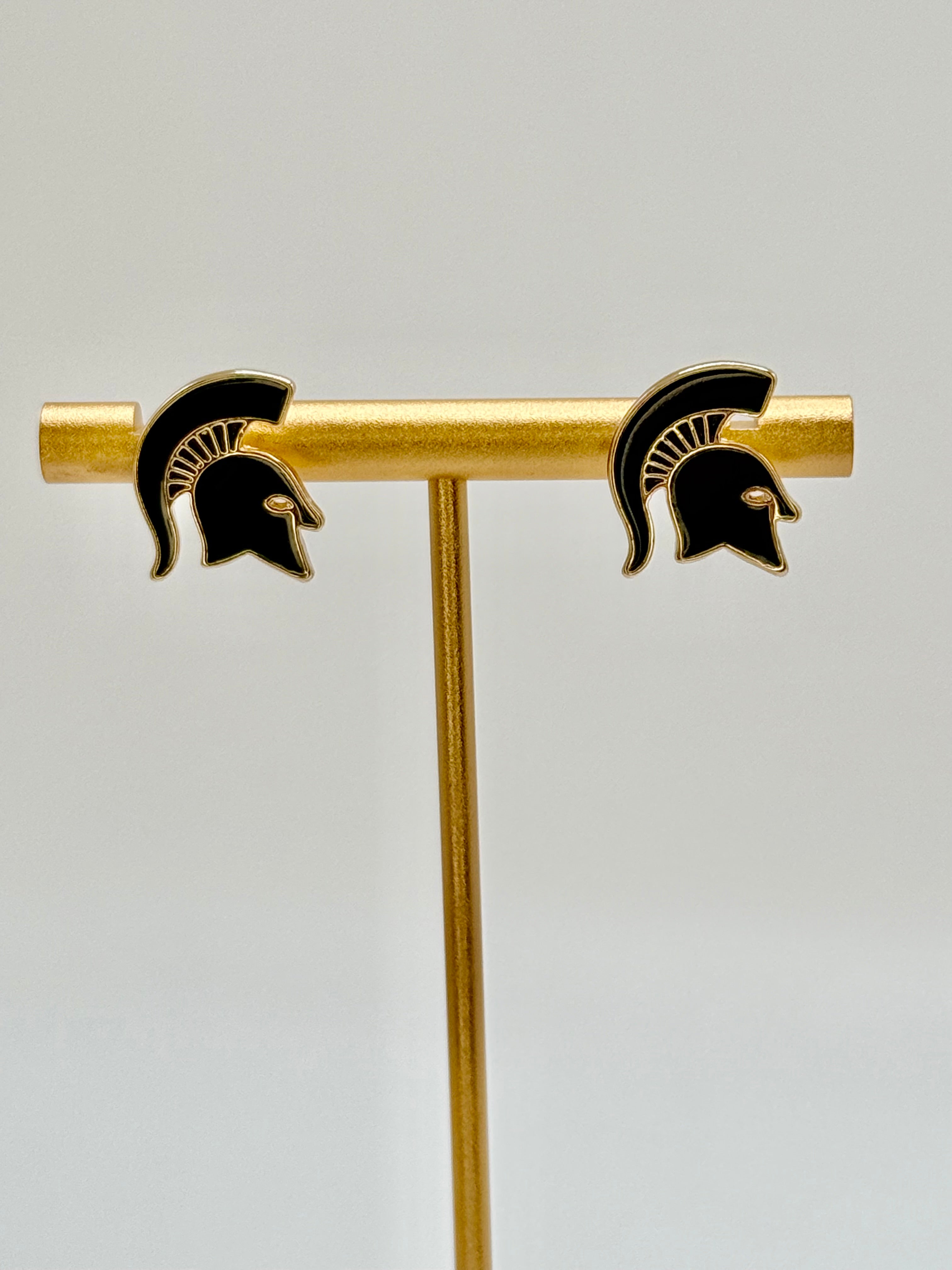 A pair of gold and dark green plated stud earrings shaped as a Spartan helmet logo. 