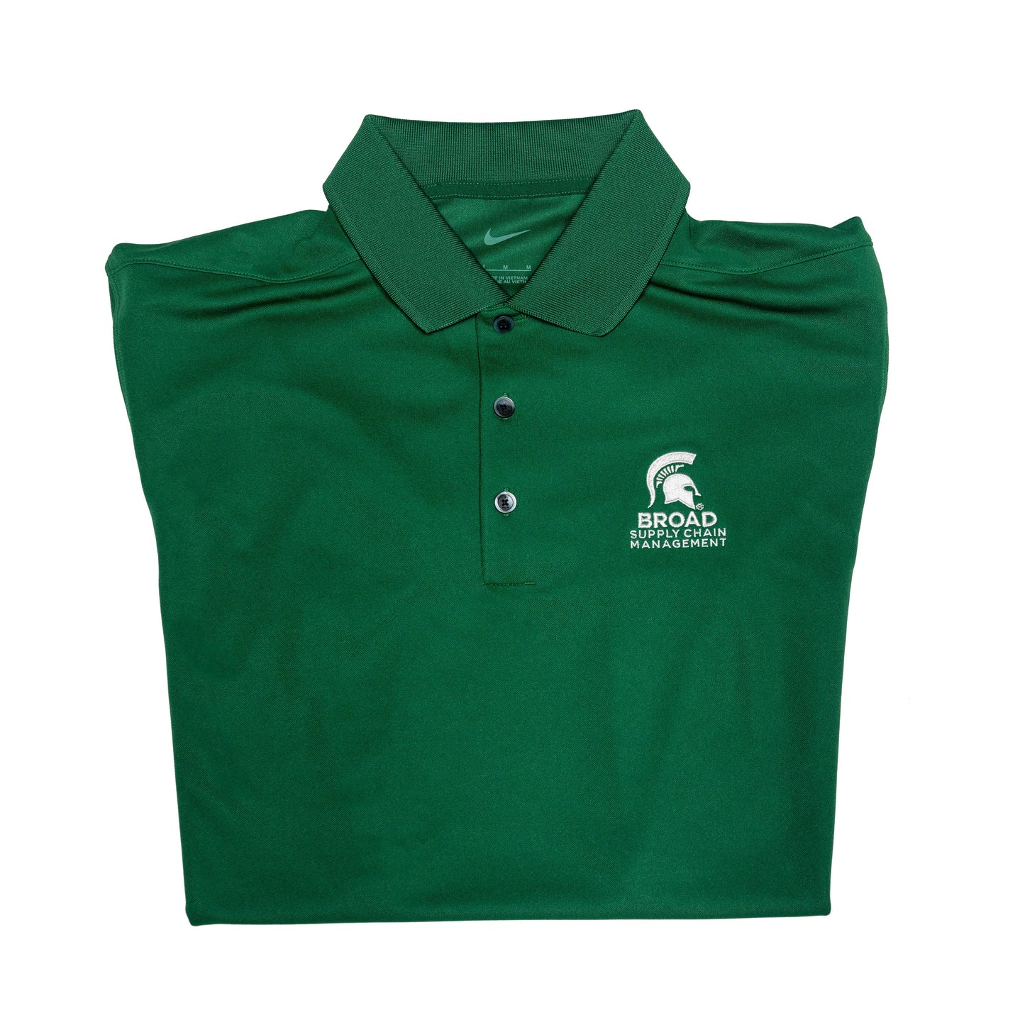 Close-up of a folded green Nike collared polo with three buttons. A white Spartan Helmet over the Broad Supply Chain Management logo is embroidered on the left upper chest.