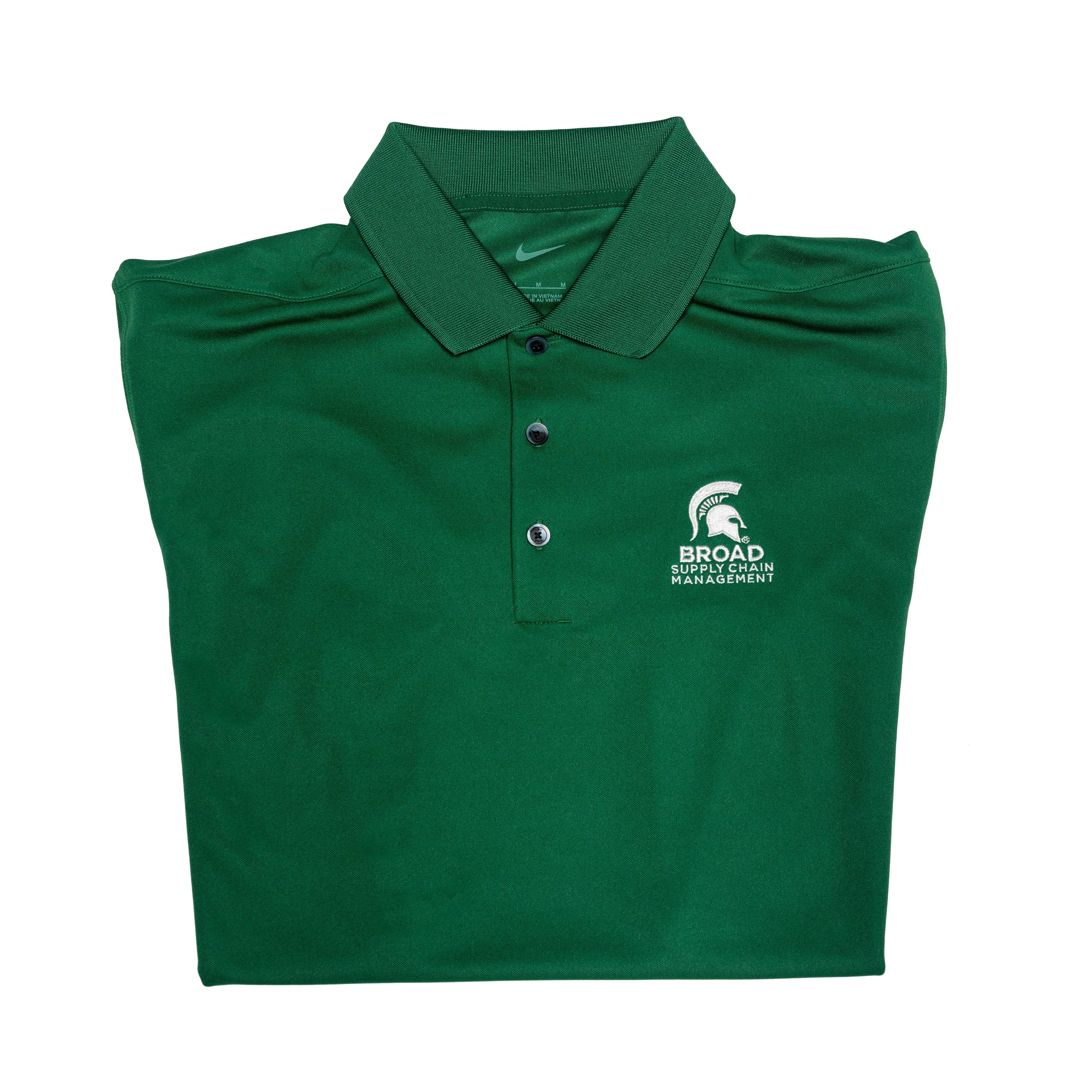Close-up of a folded green Nike collared polo with three buttons. A white Spartan helmet over the Broad Supply Chain Management logo is embroidered on the left chest.