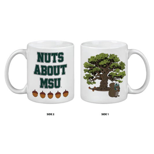 White ceramic mug with two designs: one side shows a green tree with a squirrel wearing an MSU helmet at its base; the other side features the text 'NUTS ABOUT MSU' in bold green letters above five acorns.