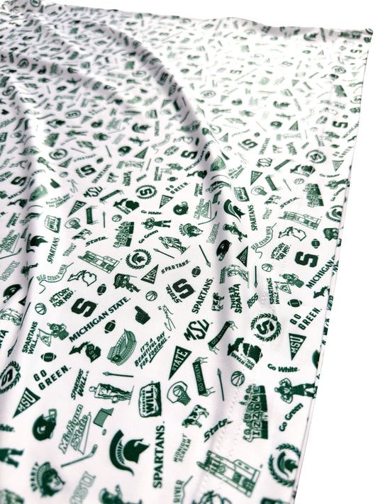 White fabric with various Michigan State landmarks and logos in green. 