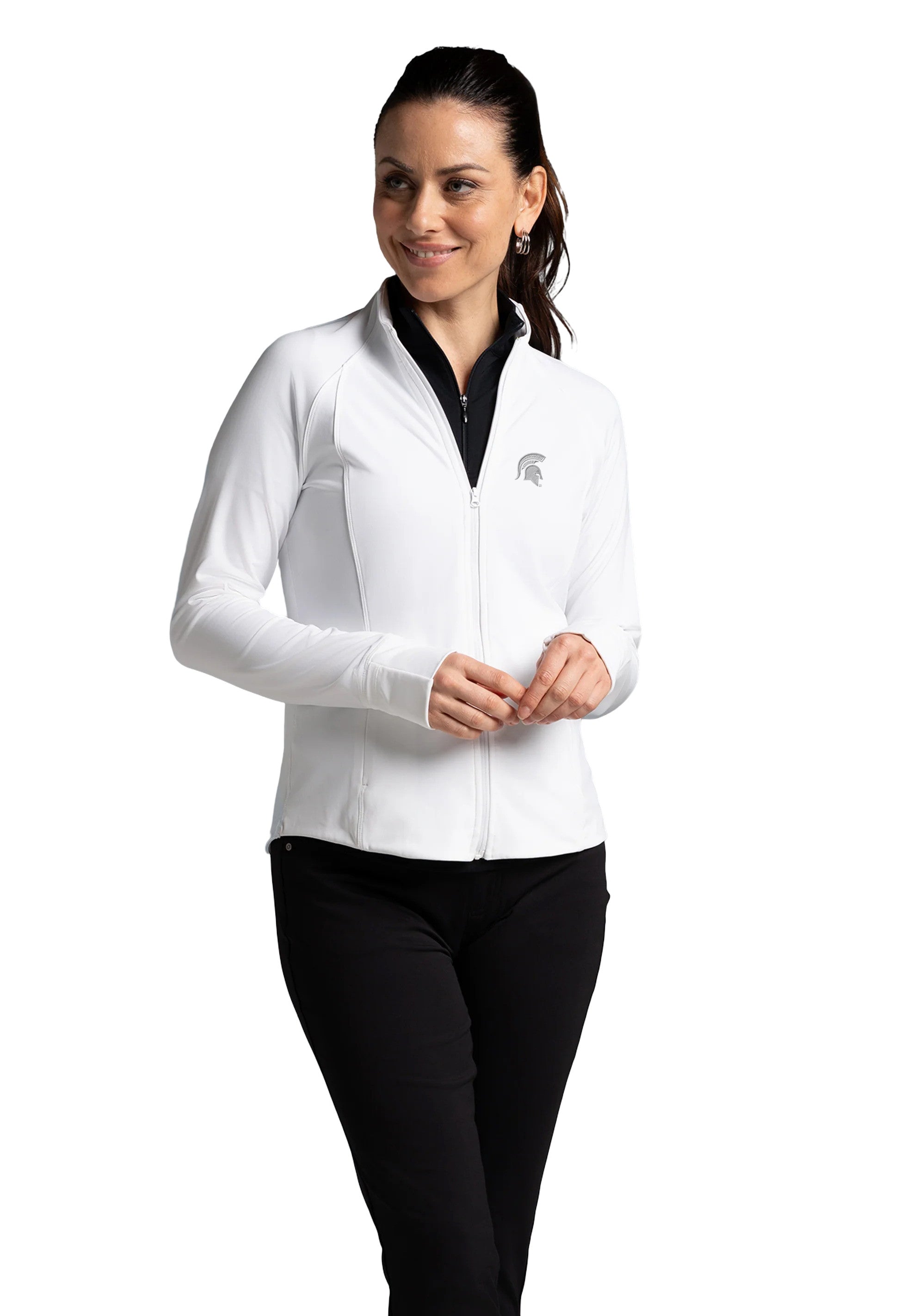 Woman wearing a white fitted, full-zip jacket with a gray Spartan Helmet logo on the upper left chest. 