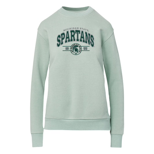 Light blue crewneck pullover with gray arched text that reads "Michigan State," arched text below in green that states "Spartans," and a graphic below that features a green Spartan Helmet logo. 
