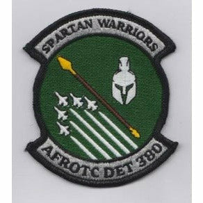 AFROTC detachment 380 logo of 5 fighter jets, a spear, and a spartan helmet in a green circle. Silver bars jut out on the top and bottom reading Spartan Warriors and AFROTC DET 380, respectively.