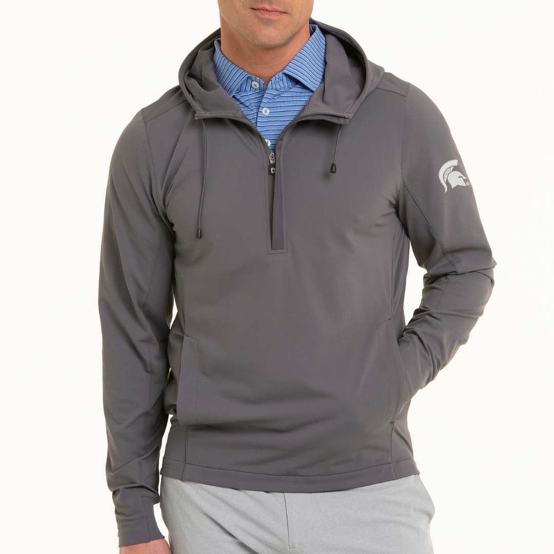Person wearing a gray quarter-zip hoodie with a Spartan Helmet logo on the left sleeve, a blue collared shirt underneath, and light gray pants.