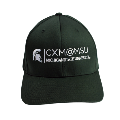 Front of a green baseball cap embroidered with the CXM@MSU signature logo and Spartan Helmet logo, both in white.